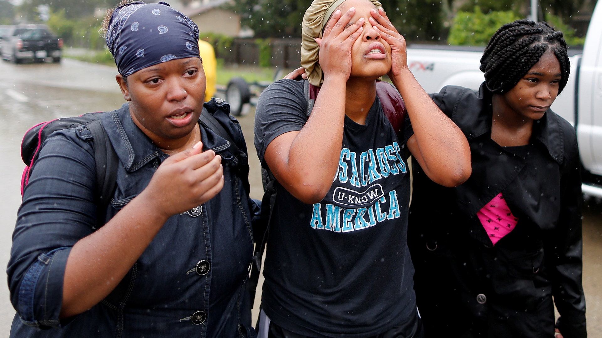 Domenique Scales wipes tears from her face after being rescued from the flood waters in Beaumont Place, Texas, Monday
