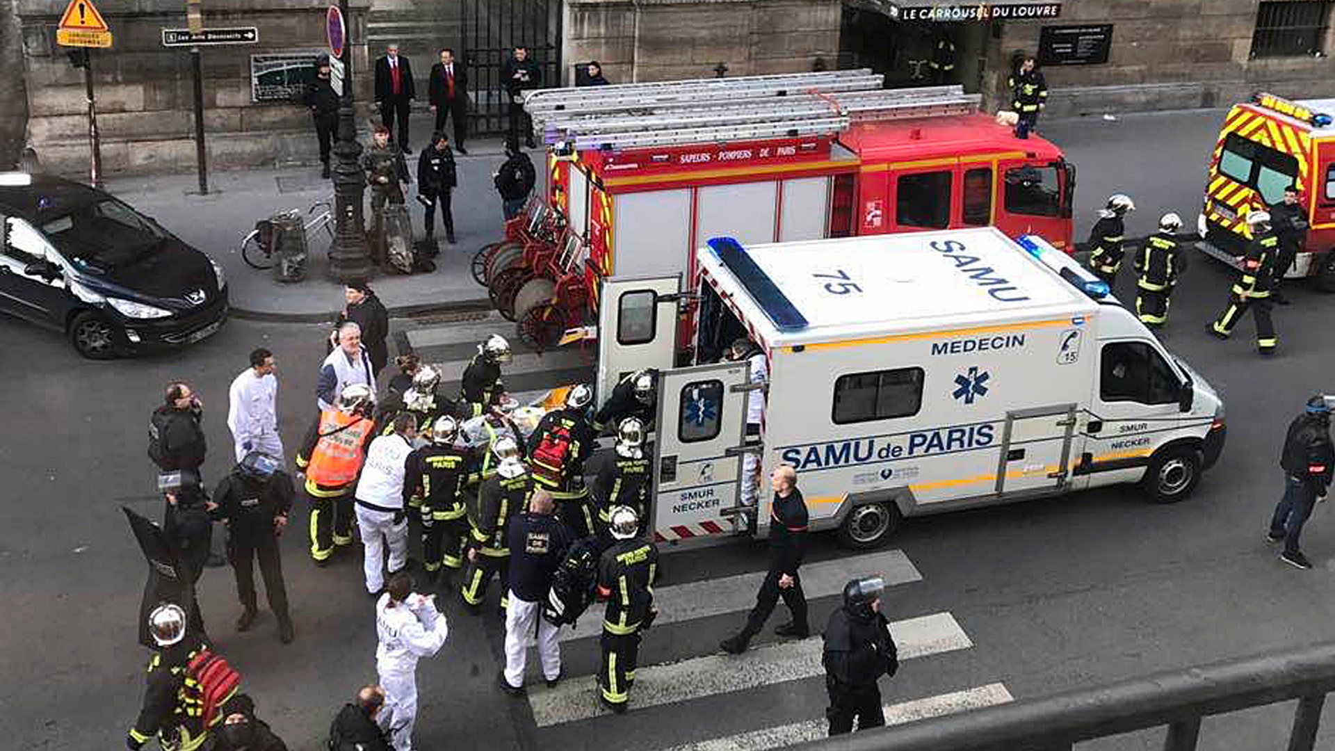 In this photo provided by Sheng Zihao, an unidentified wounded person is taken into an ambulance in Paris, Friday, Feb. 3, 2017.