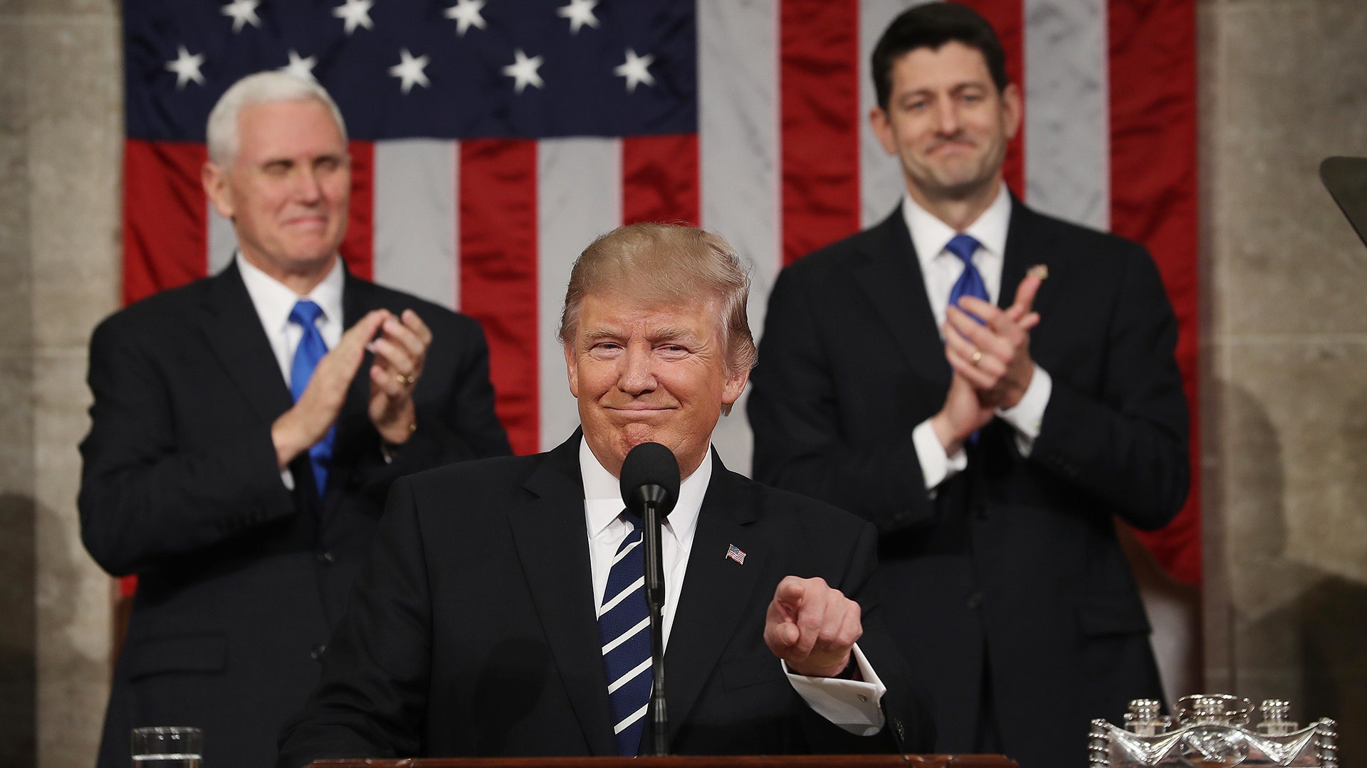 Vice President Mike Pence (L) and House Speaker Paul Ryan (R) applaud as President Donald J. Trump arrives to deliver his first address to a joint session of Congress.