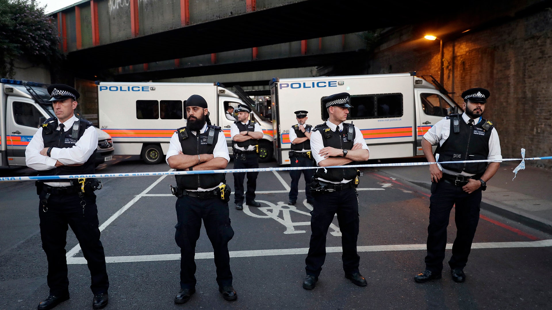 Police stand guard at a cordon on a road near Finsbury Park station after a vehicle struck pedestrians in north London