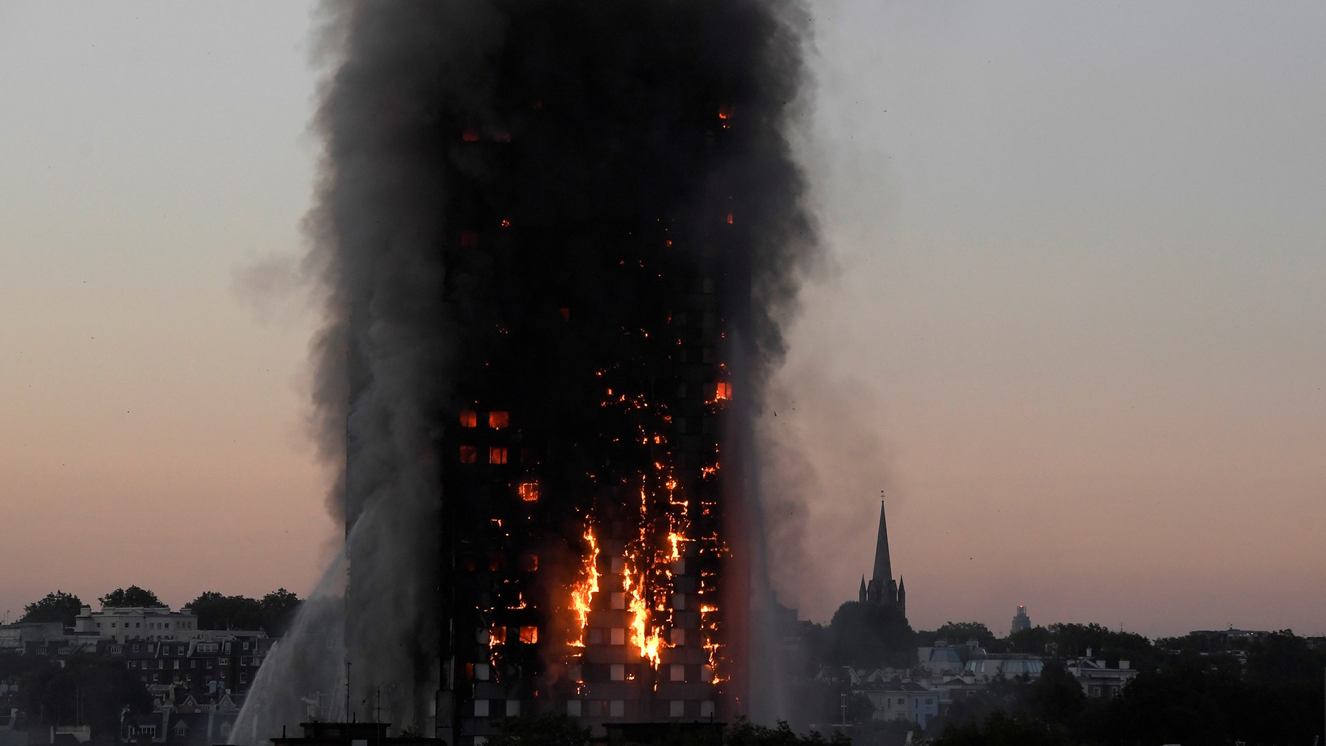Flames and smoke billow as firefighters deal with a fire in the Grenfell Tower apartment block in West London, Britain, June 14