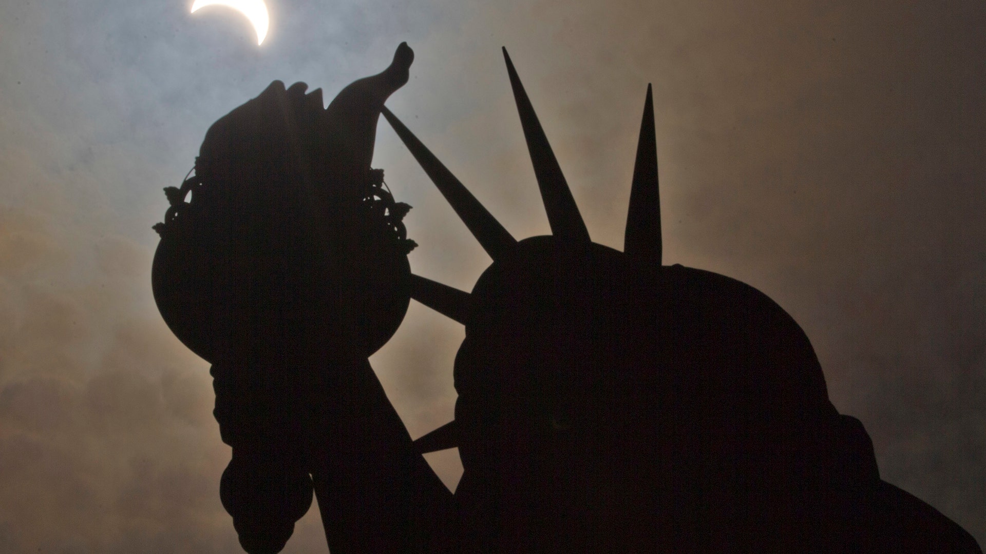 A partial solar eclipse is seen near the Statue of Liberty on Liberty Island in New York