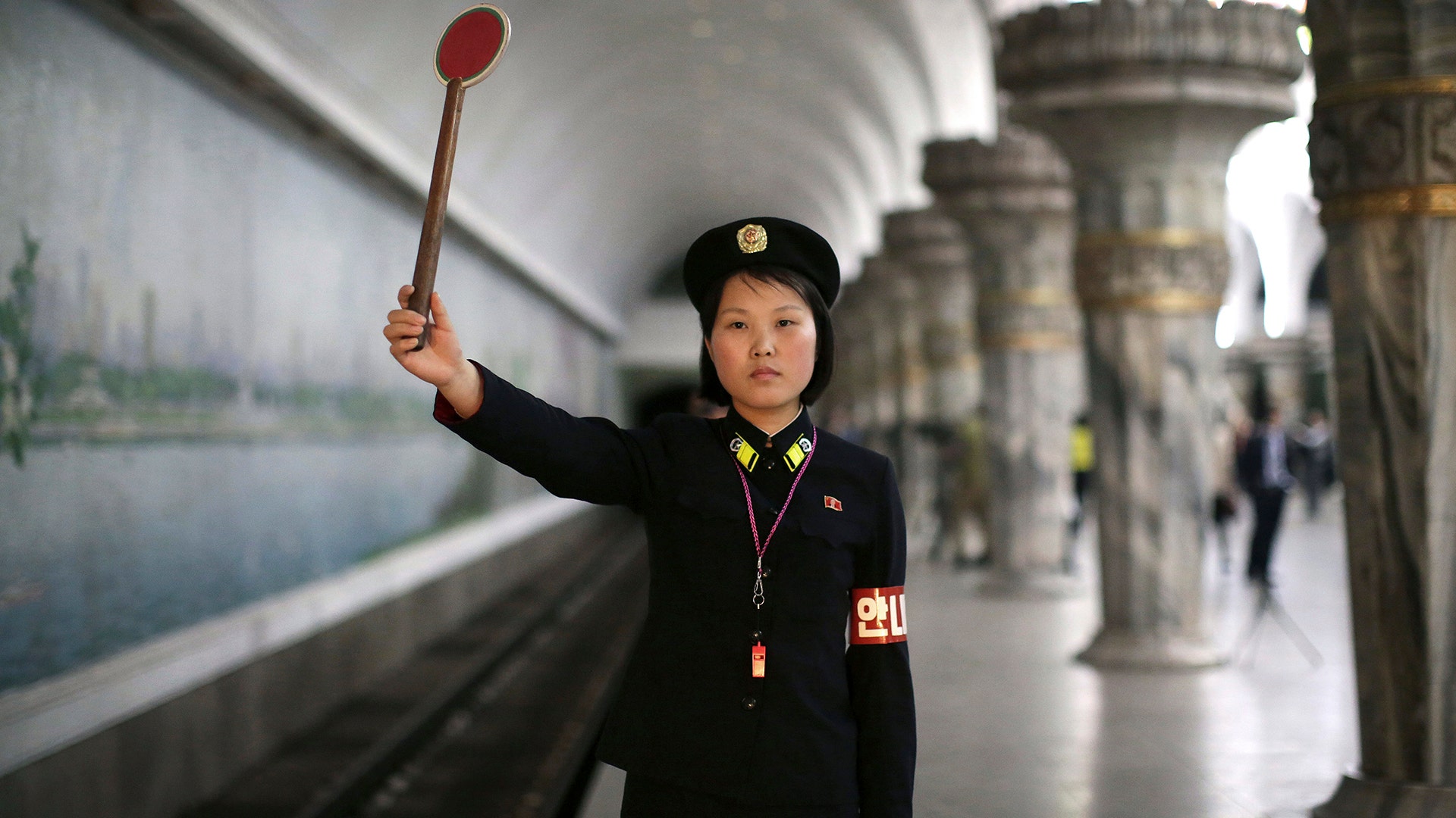 Pyongyang subway officer Ri Ok Gyong, 23, holds up a signal as she poses for a portrait in Pyongyang, North Korea, May 7, 2016