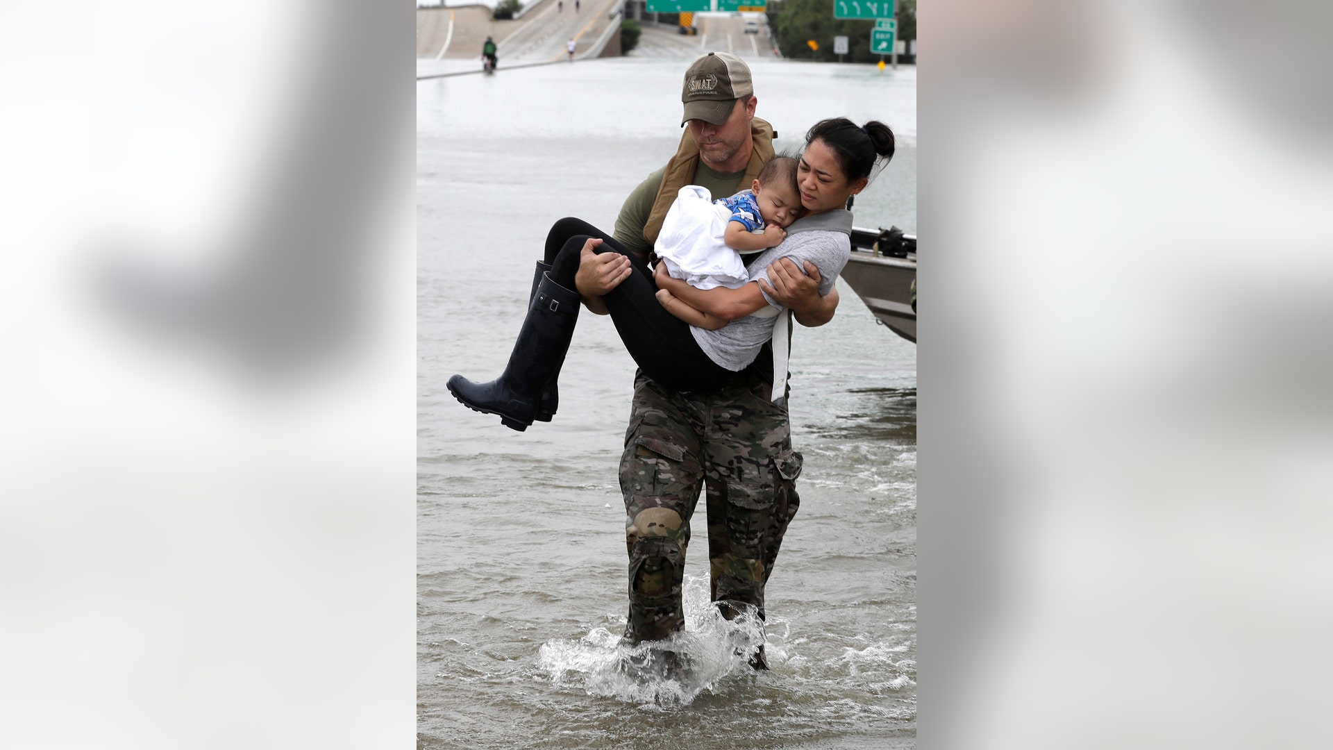 Houston Police SWAT officer Daryl Hudeck carries Catherine Pham and her 13-month-old son Aiden from flood waters in Houston, August 27