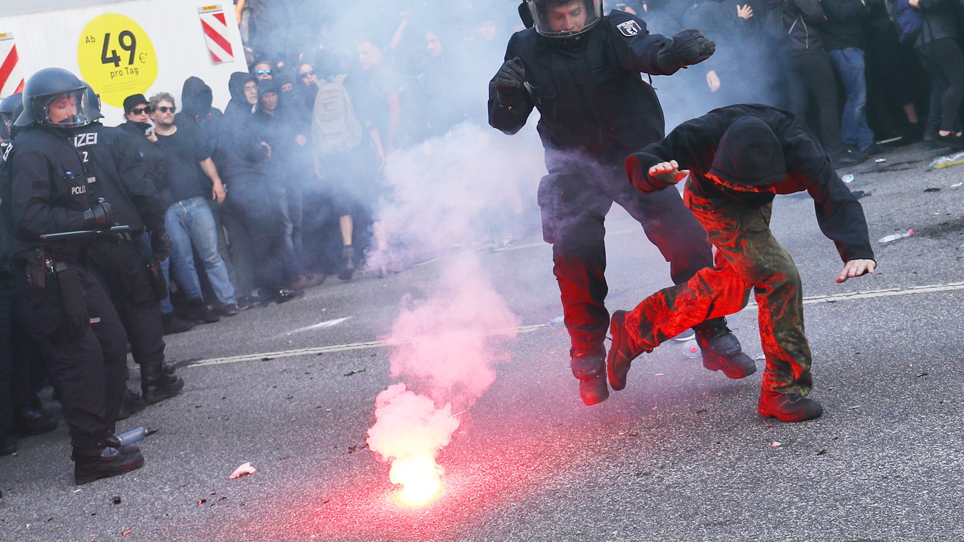 A German riot policemen catches a protester during the demonstrations at the G-20 summit in Hamburg, Germany