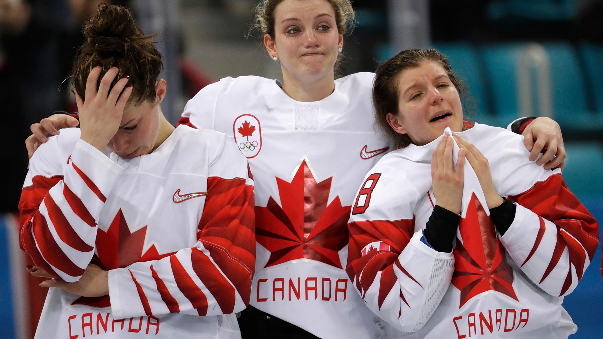Team Canada players wait for their silver medals during the medals ceremony for women's hockey at the 2018 Winter Olympics 