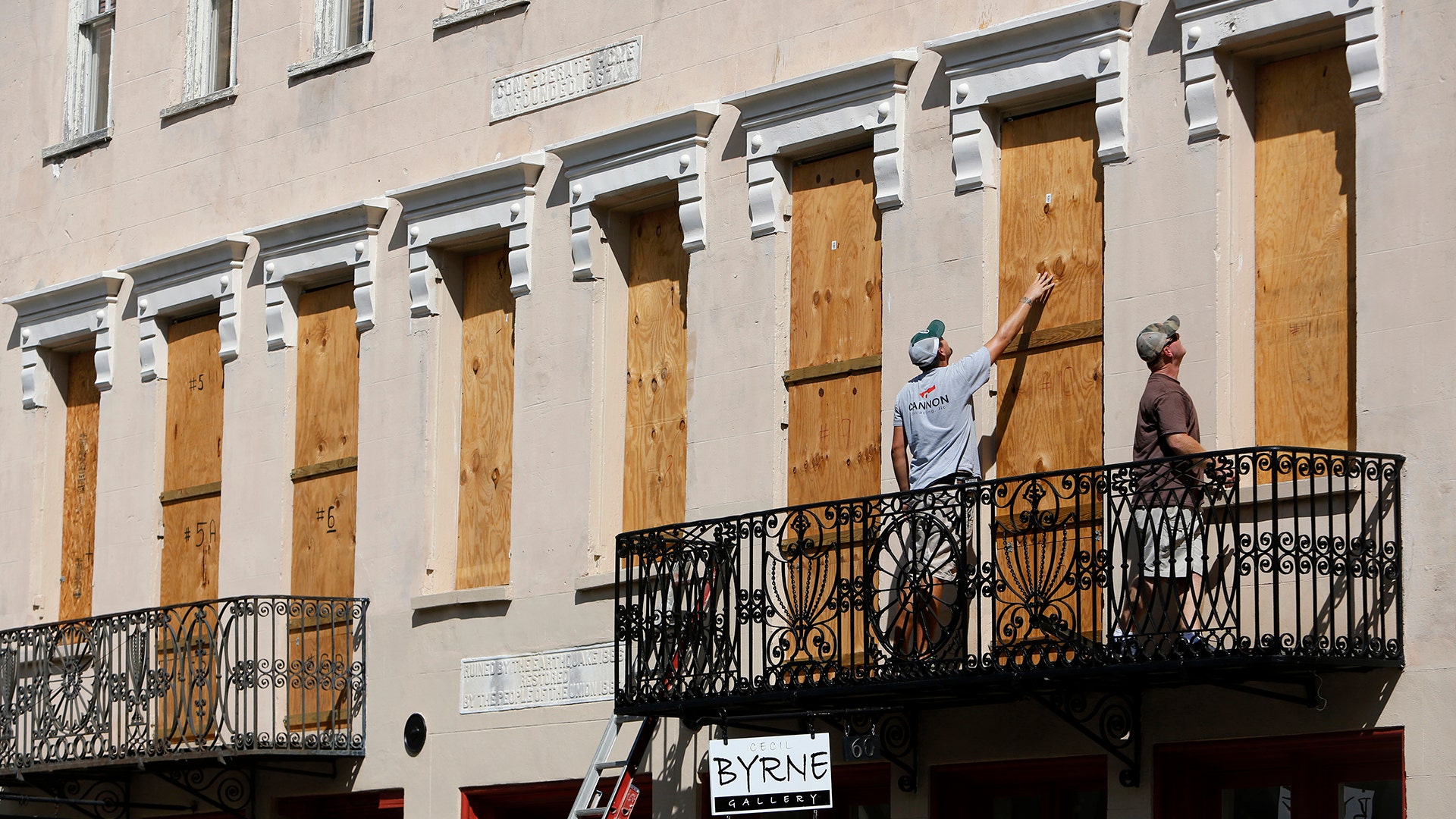 Derek Mundy and Kris Crouse board up the Confederate House in preparation for Hurricane Florence in Charleston, South Carolina, Tuesday