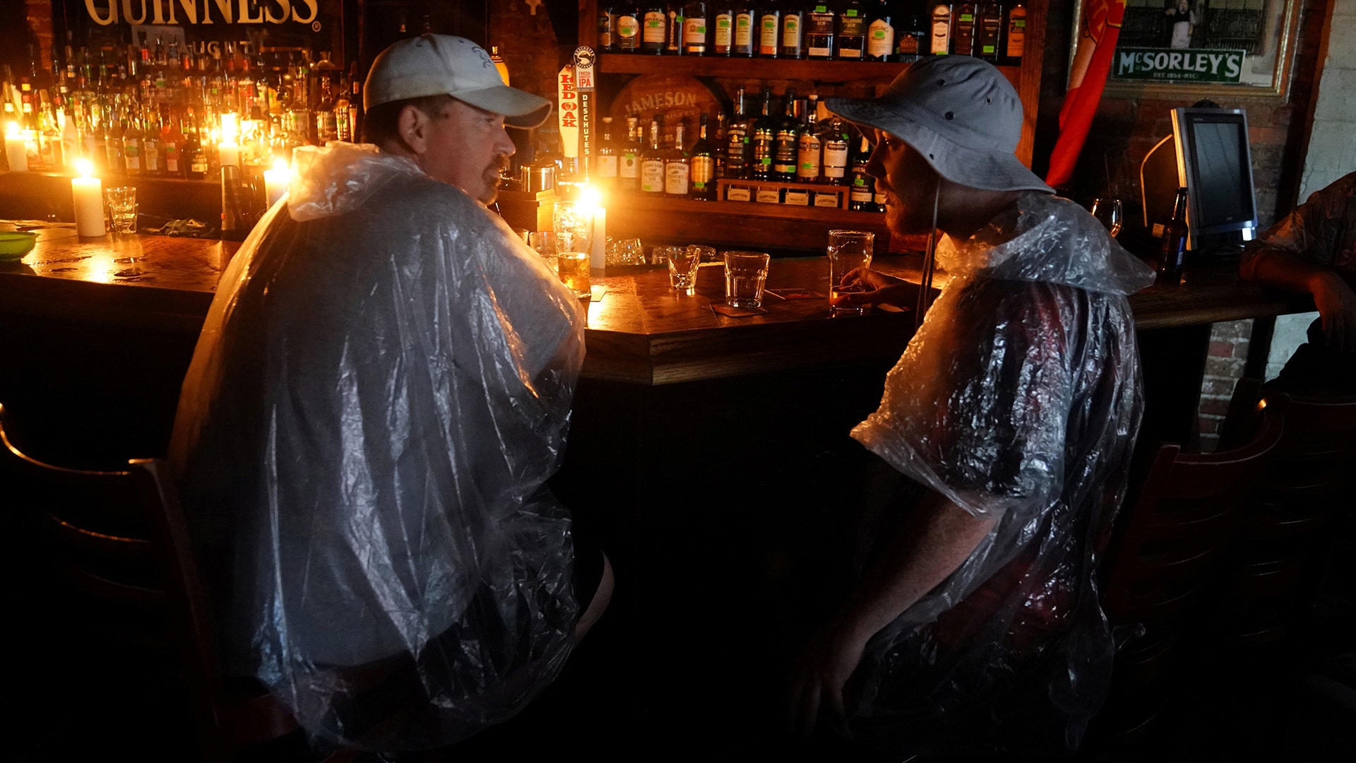 People sit at a bar that has no power and drink during a Hurricane Party in Wilmington, North Carolina, Friday