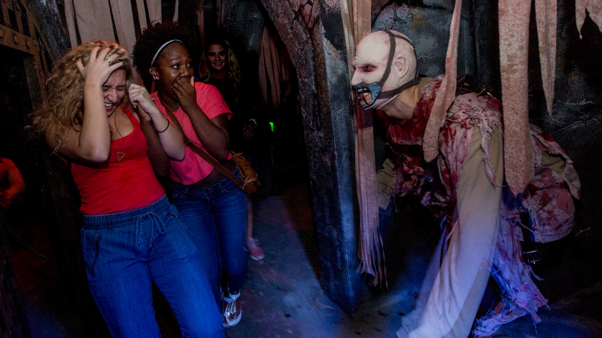 Two women scream at the masked actor.