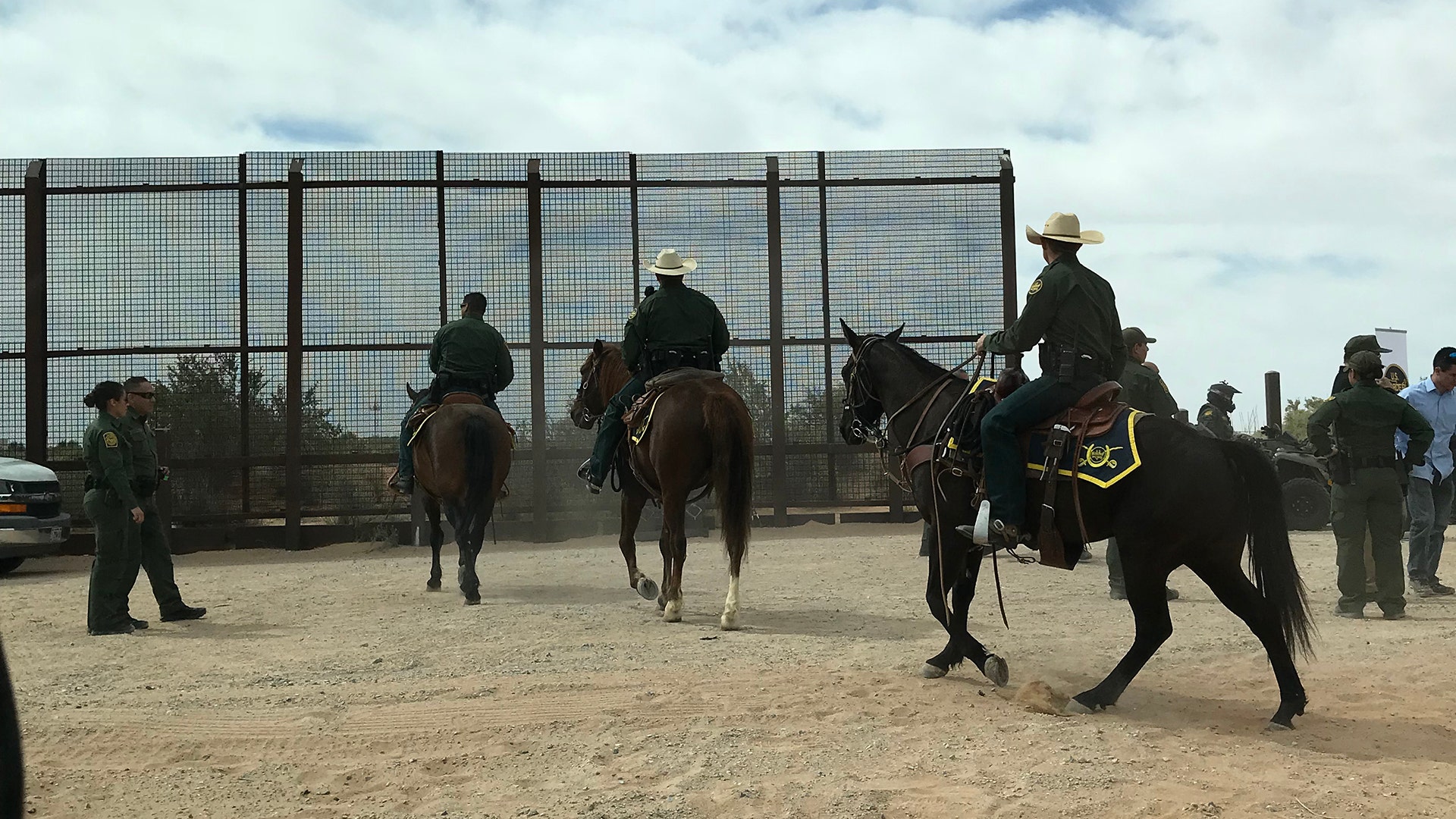 The border patrol on horses in front of the wall