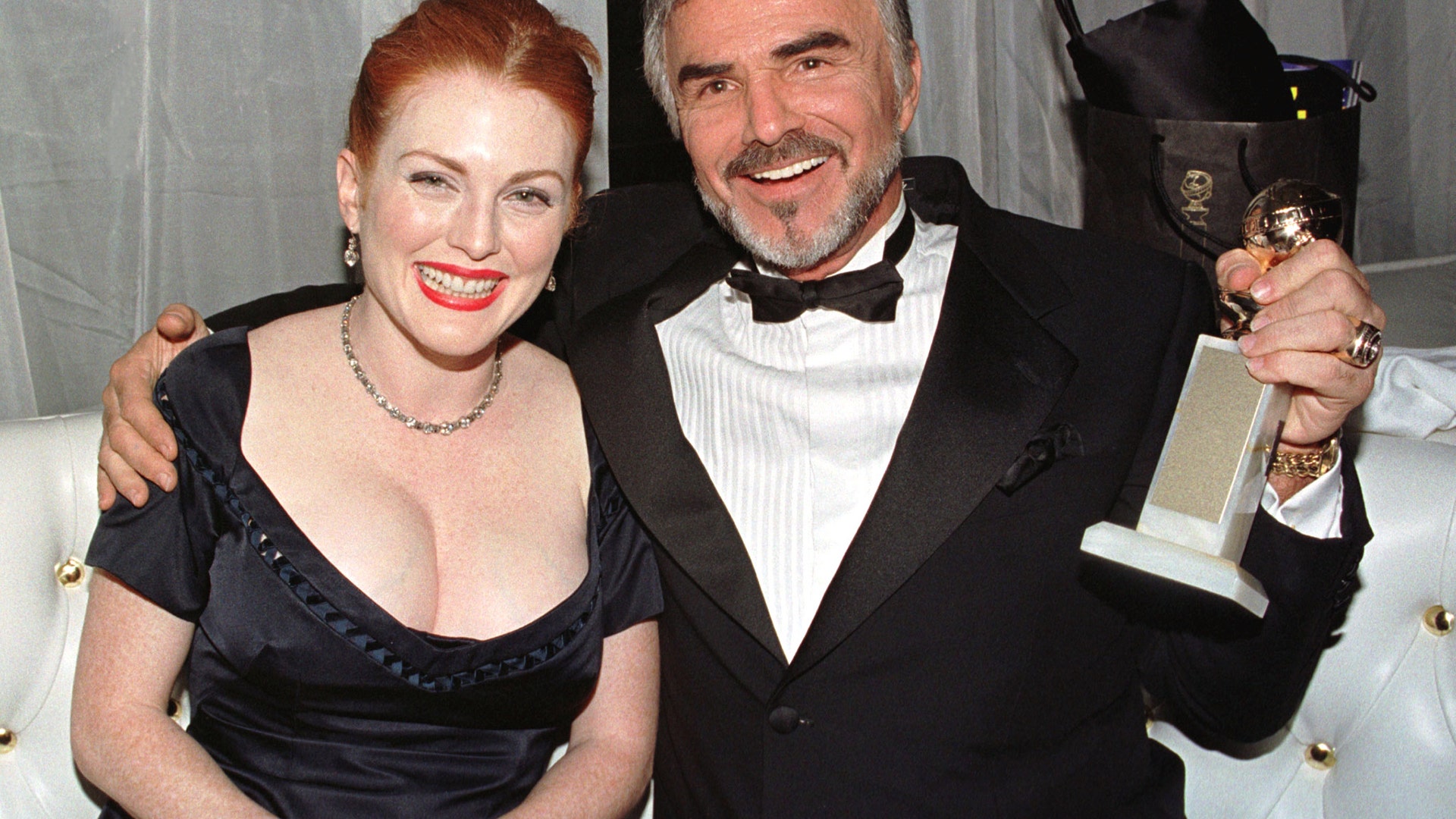 Burt Reynolds with his Golden Globe Award for 'Boogie Nights,' next to Julianne Moore in 1998.