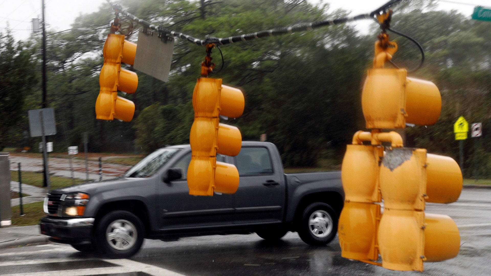 A motorist drives past fallen traffic lights in Wilmington, North Carolina, Friday