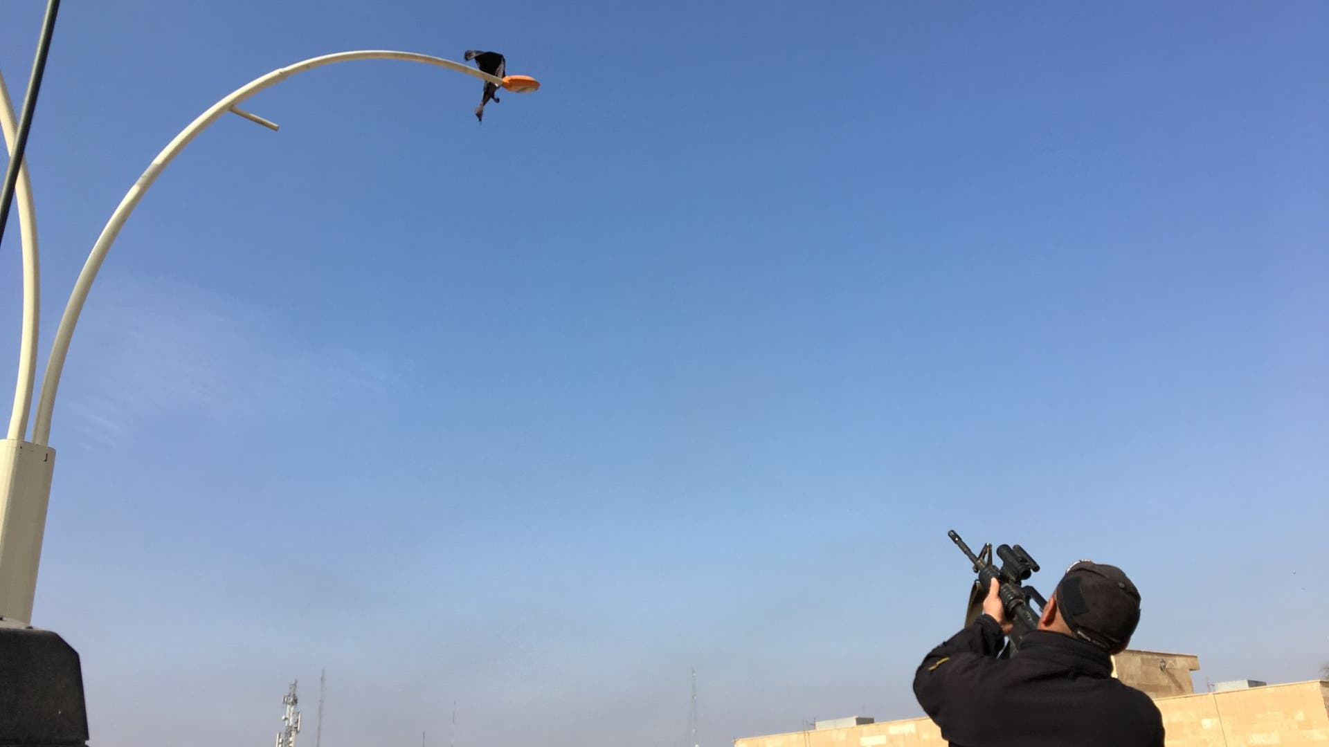 Iraqis shoot at an ISIS flag to celebrate after eastern Mosul is fully liberated. 