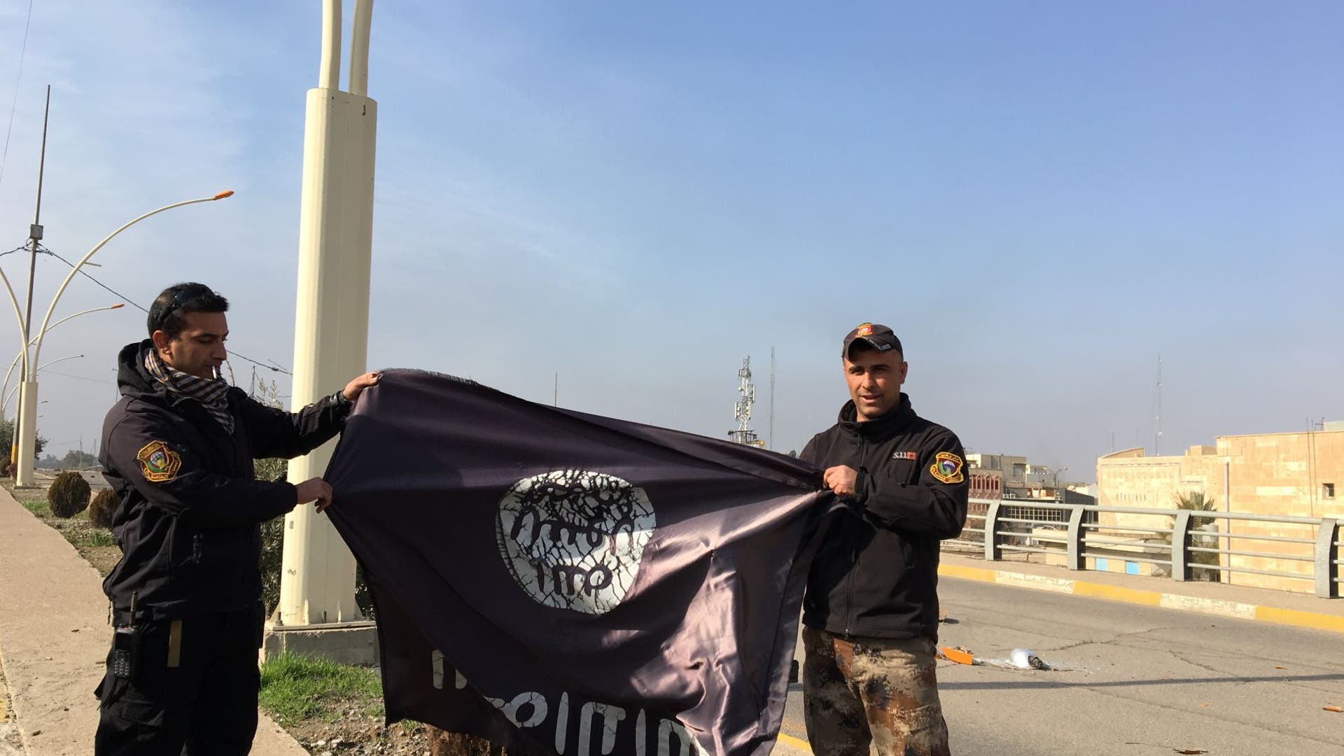 ISIS flag is used as a trophy to celebrate Iraq's takeover of eastern Mosul. 