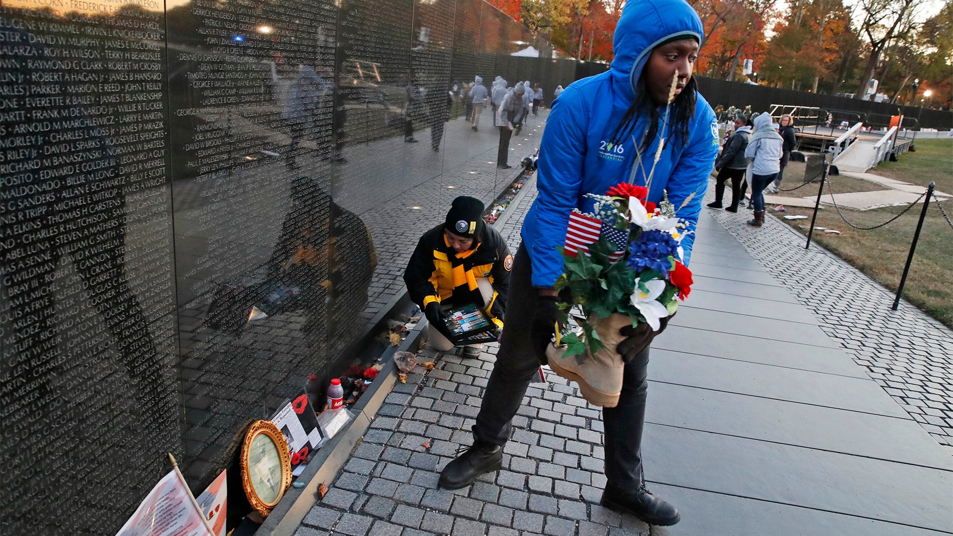 Volunteers remove mementos before cleaning the wall at the Vietnam Veterans Memorial on Veterans Day