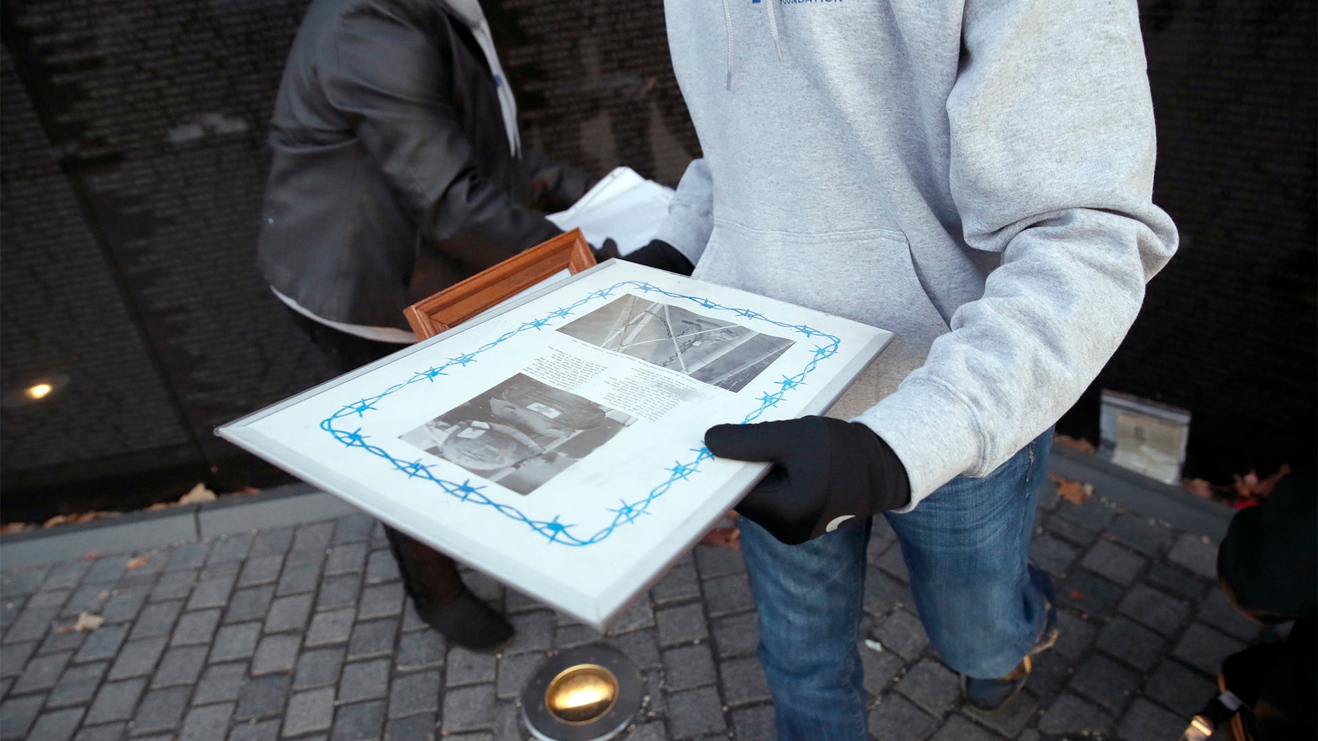 Volunteers remove mementos before cleaning the wall at the Vietnam Veterans Memorial on Veterans Day