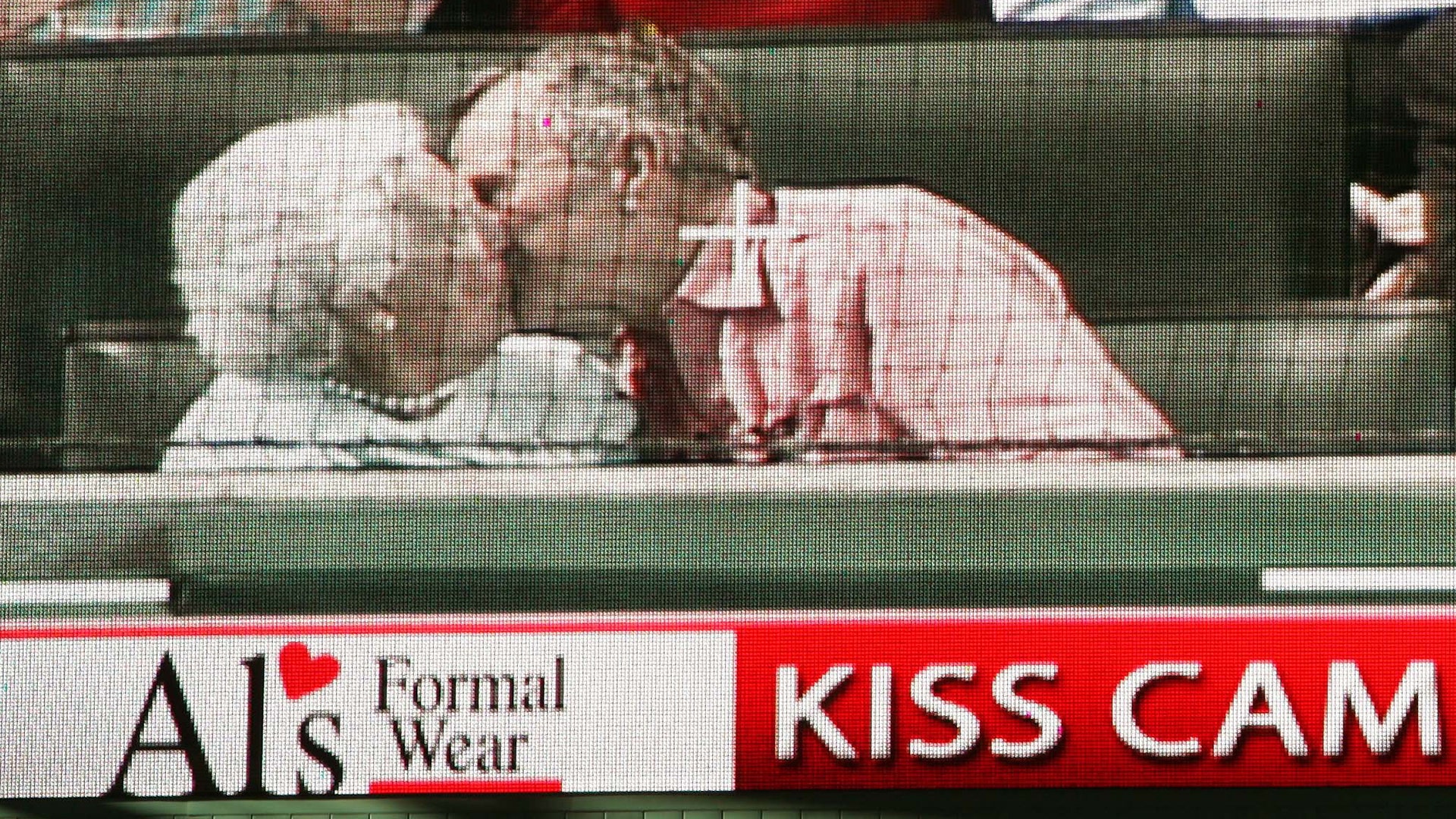 Former U.S. president George Bush and his wife Barbara Bush are seen kissing on a giant electronic screen