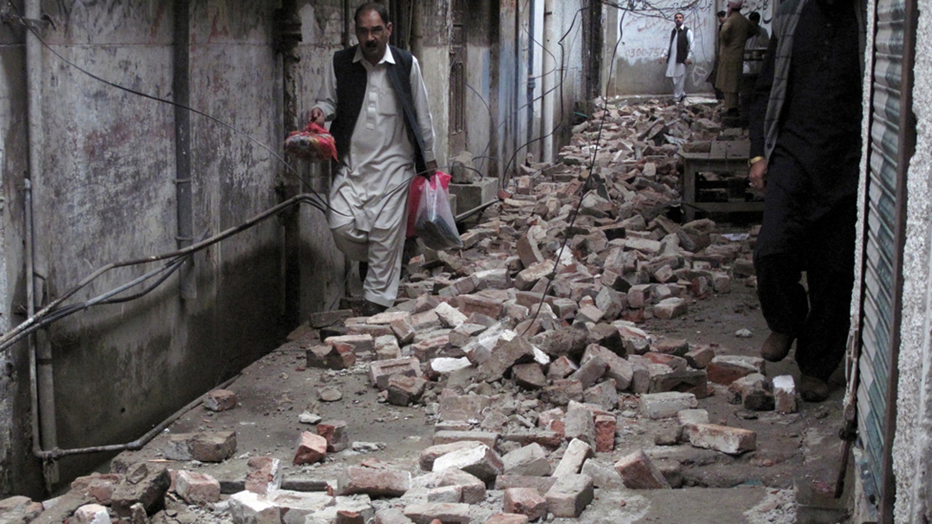A man walks past the rubble 