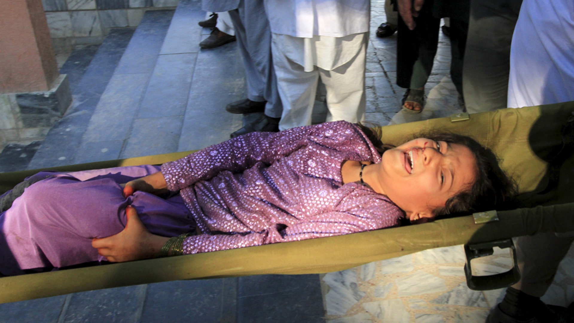 Rescue workers carry an injured girl