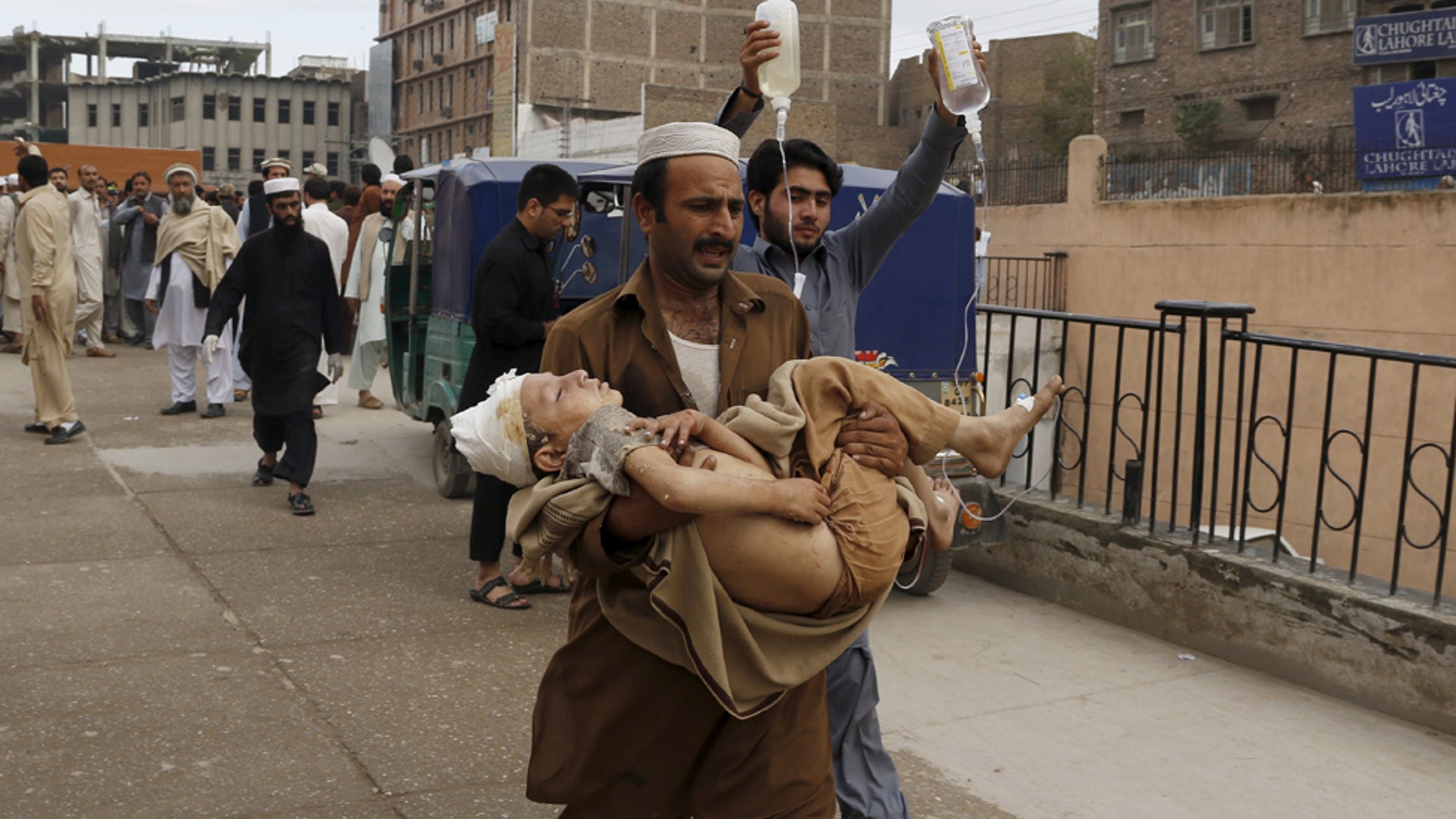 A man carries an injured boy