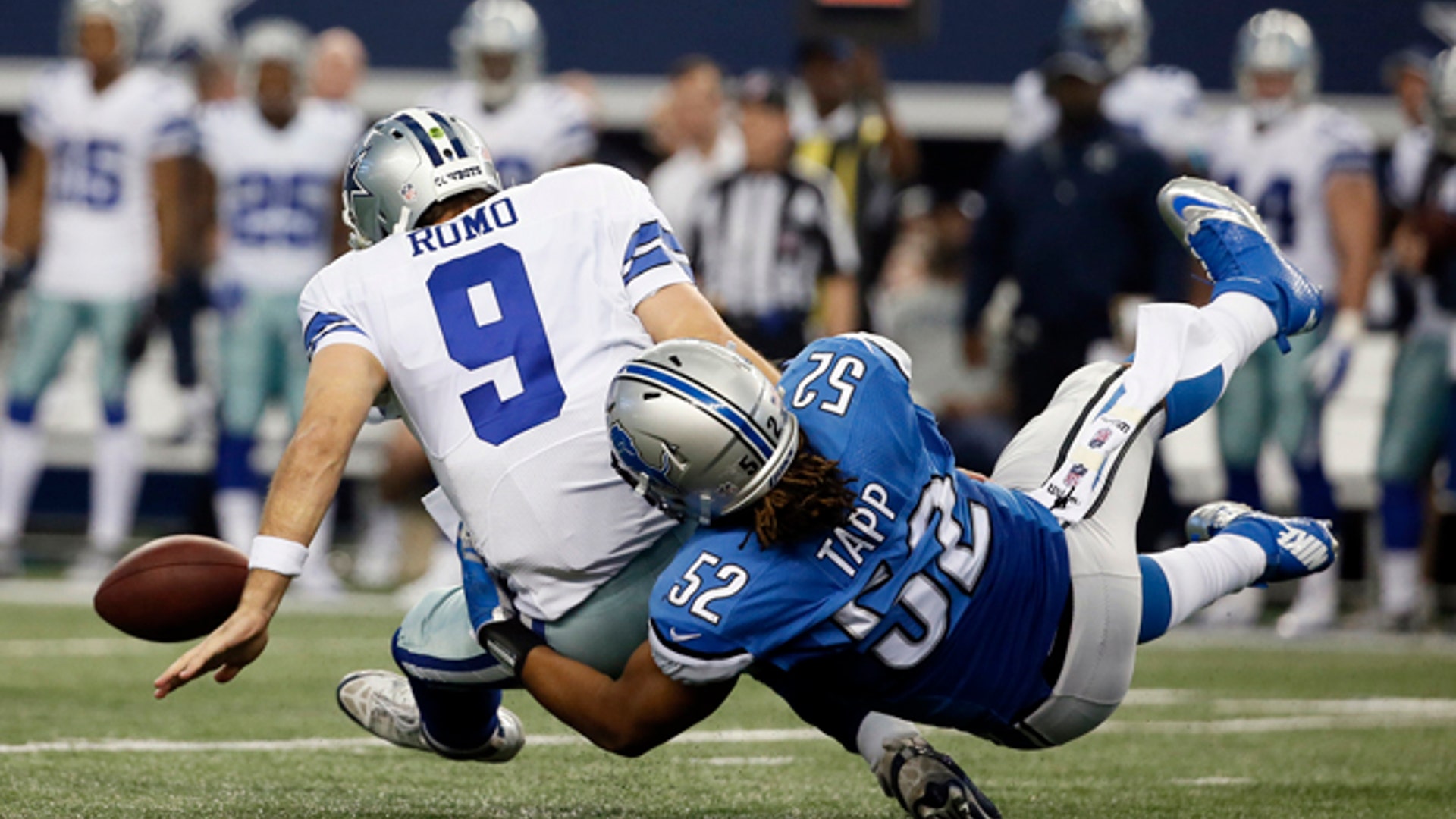 Dallas Cowboys quarterback Tony Romo (9) fumbles as he is tackled by Detroit Lions defensive end Darryl Tapp (52)