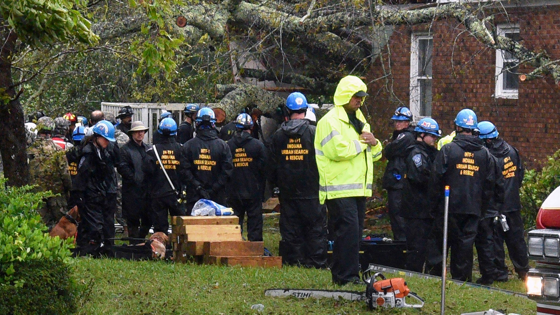 Rescue team wait to remove the bodies of a mother and child, killed by a falling tree in Wilmington, North Carolina, Friday