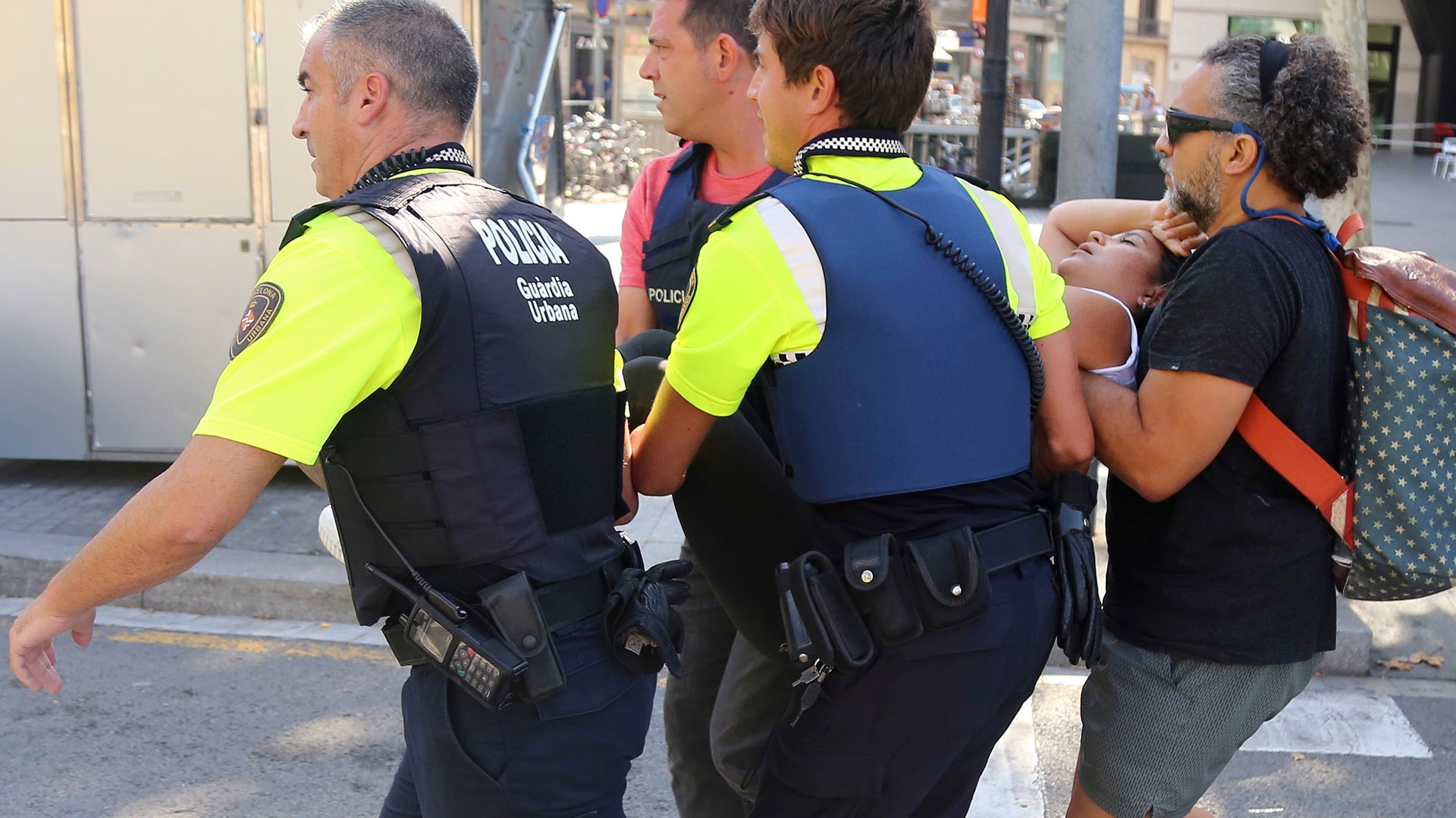 An injured person is carried after a van crashed into a summer crowd of residents and tourists on Las Ramblas in Barcelona, August 17