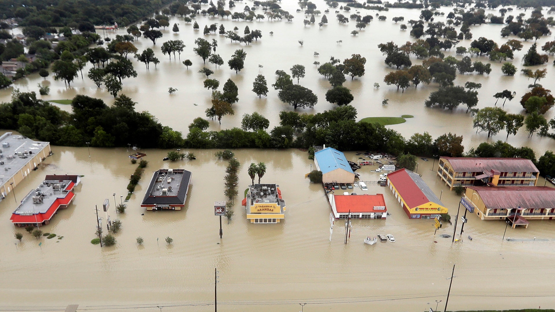 Water from Addicks Reservoir flows into neighborhoods as floodwaters from Tropical Storm Harvey rise in Houston, Tuesday