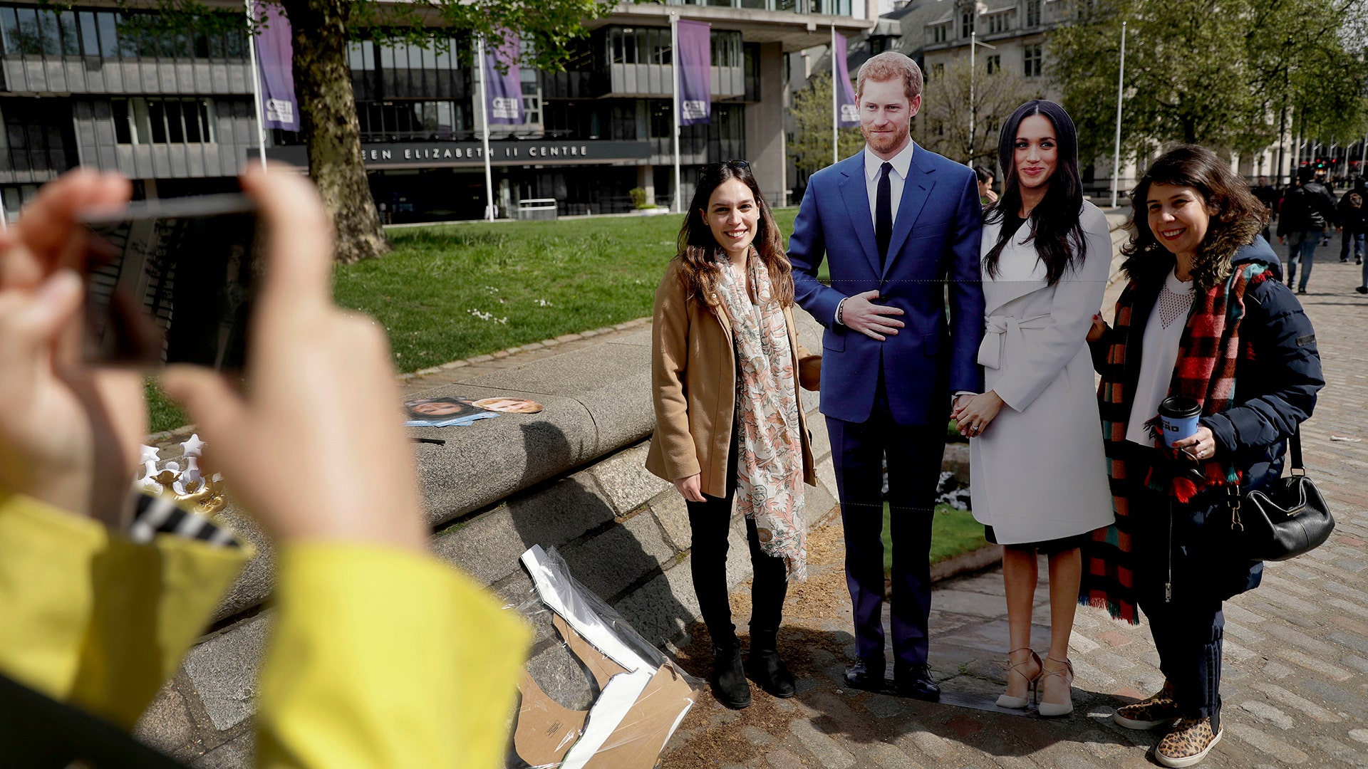 Tourists have their photo taken with cardboard cutouts of Britain's Prince Harry and his fiancee Meghan Markle, in London, May 3, 2018