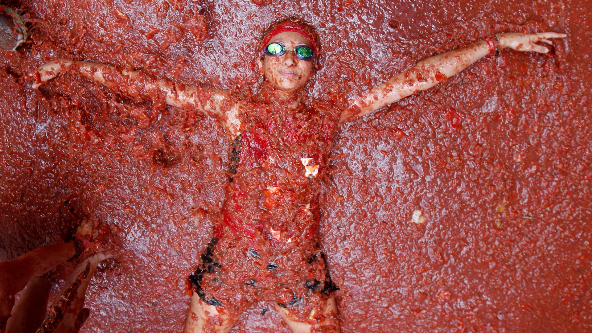 A reveler lays in tomatoes during the annual 
