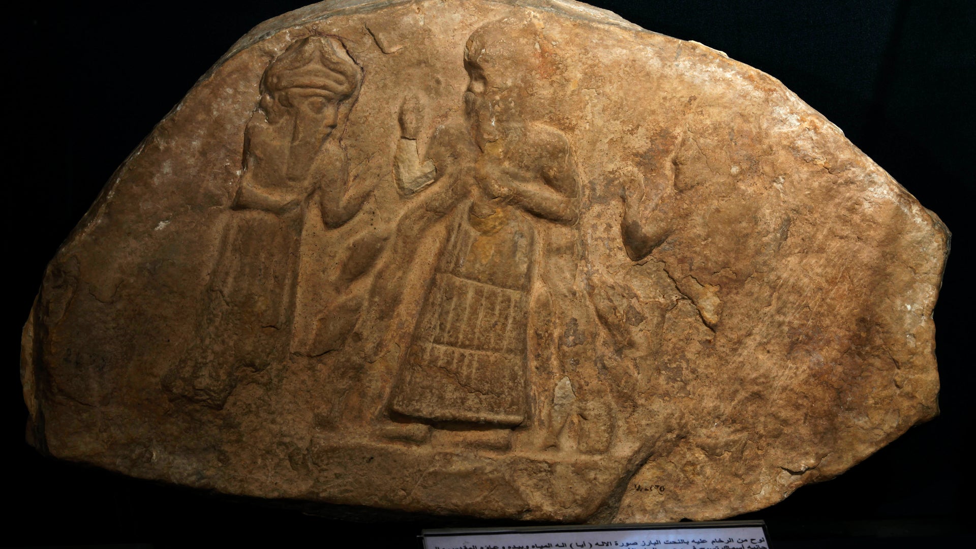 A limestone slab showing the water god, Ea, receiving a minor deity