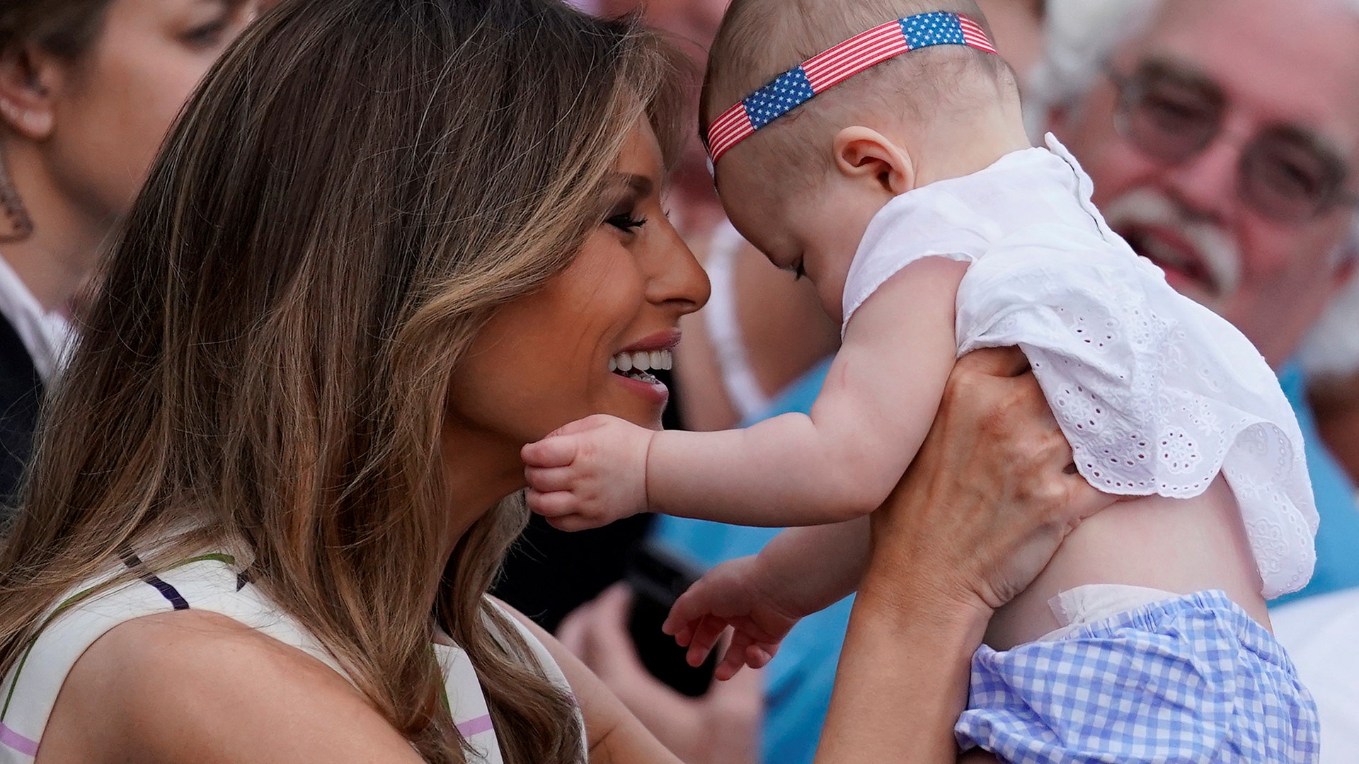 First Lady Melania Trump holds a baby during the Congressional Picnic at the White House, Thursday