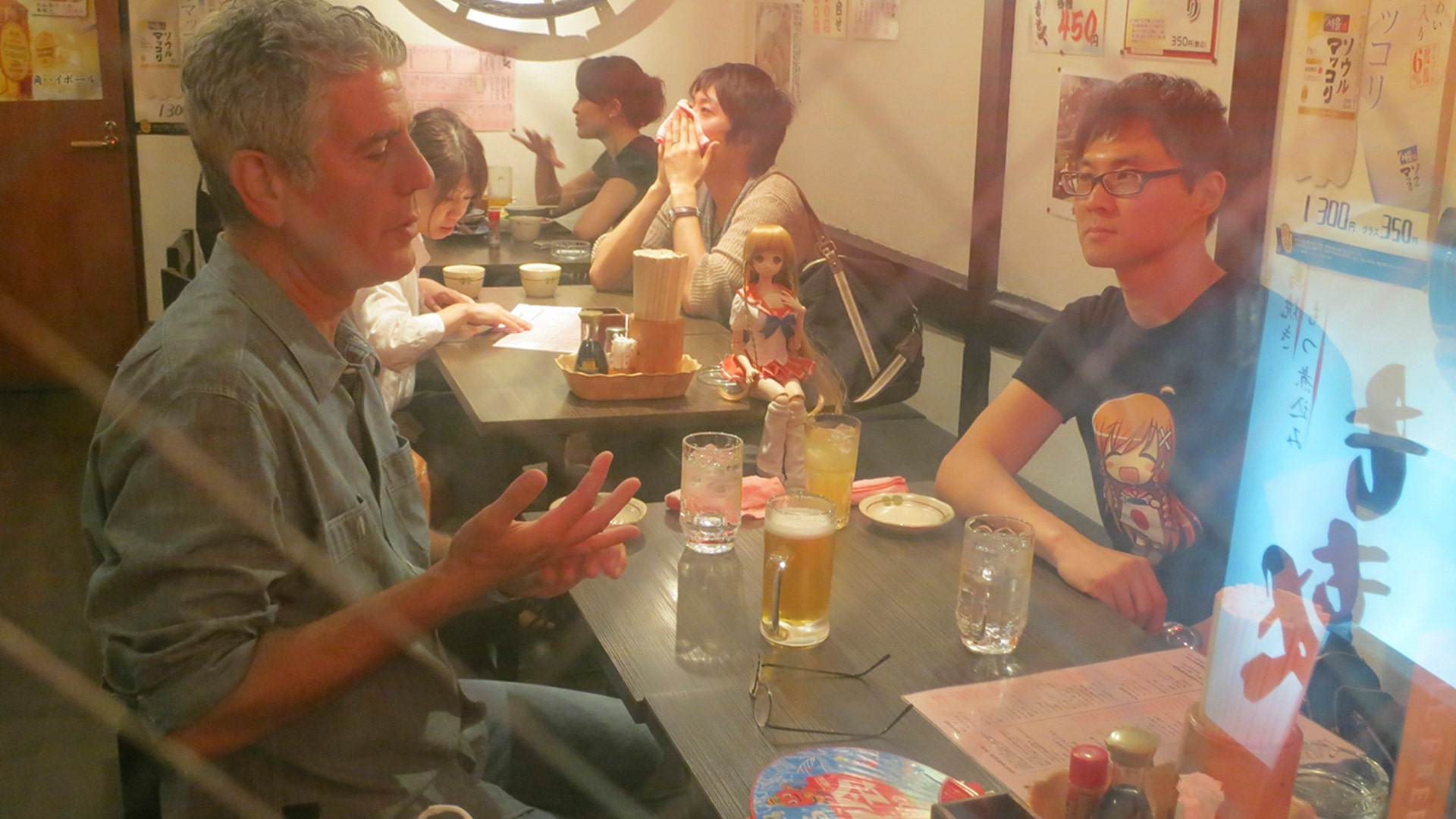 Bourdain sits down for a meal in Tokyo while filming 