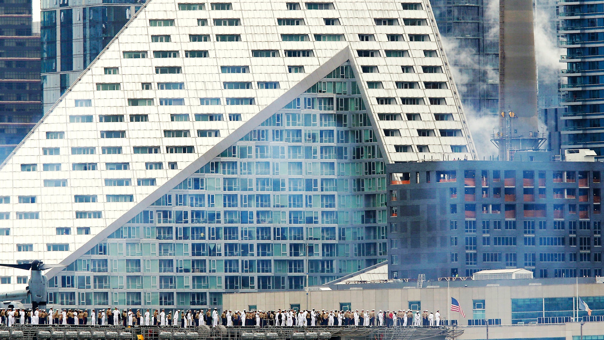 Service members stand on the deck of the USS Kearsarge as it docks on the west side of Manhattan in New York 