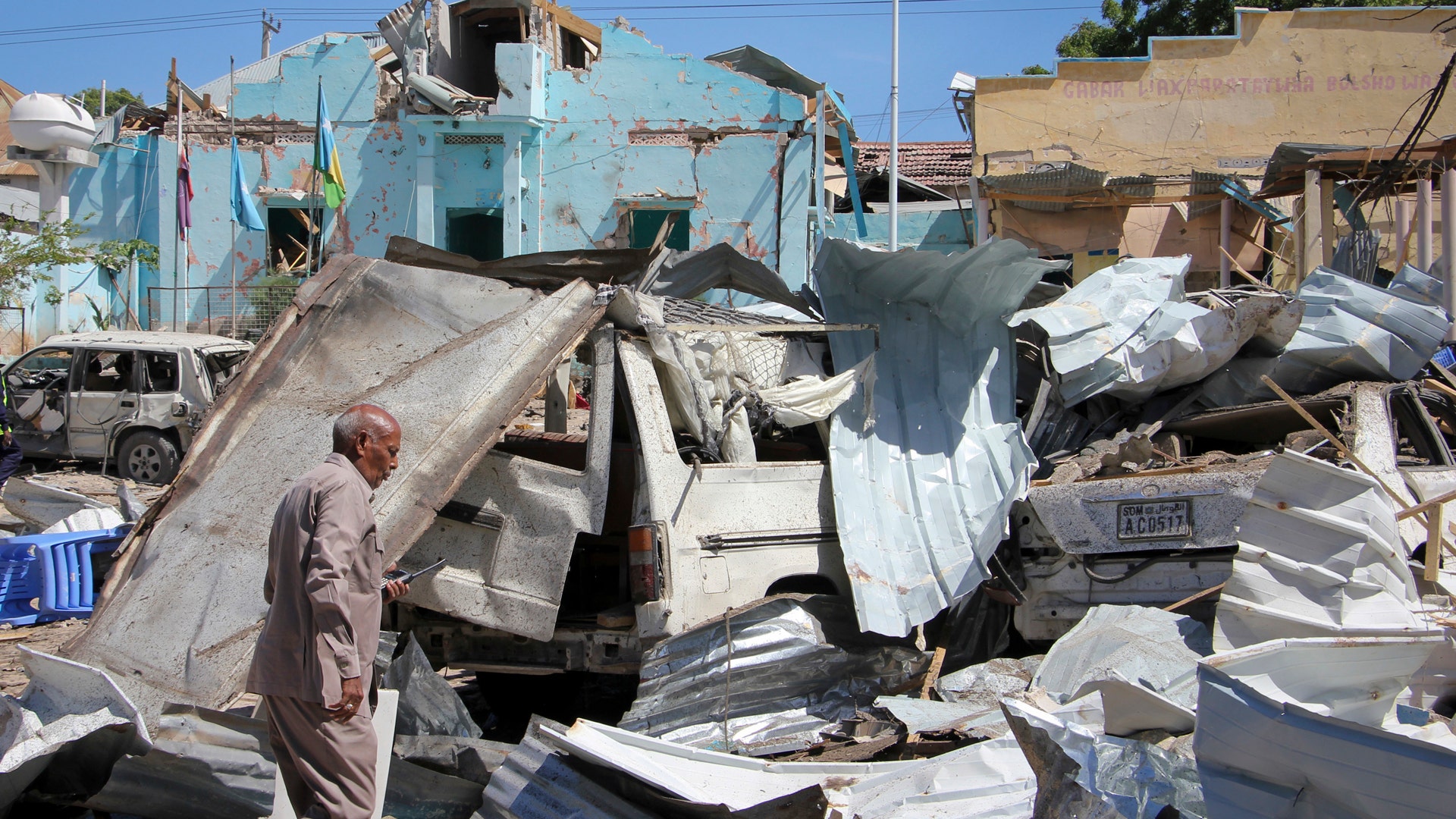 A Somali police officer walks through the destruction at the scene of a car bomb attack in Mogadishu, Somalia