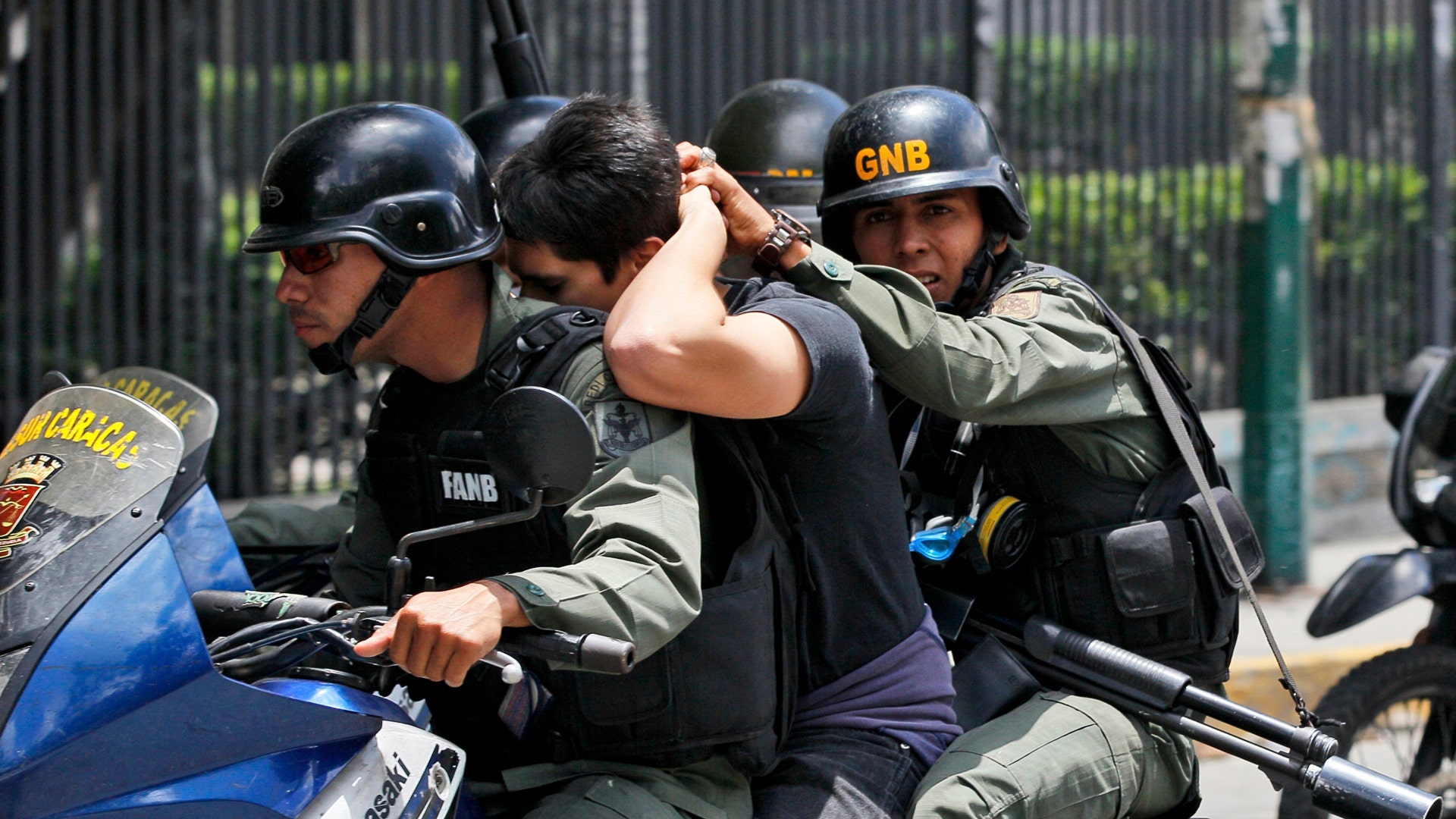 Venezuelan Bolivarian National Guard officers detain a demonstrator during clashes at Altamira Square in Caracas