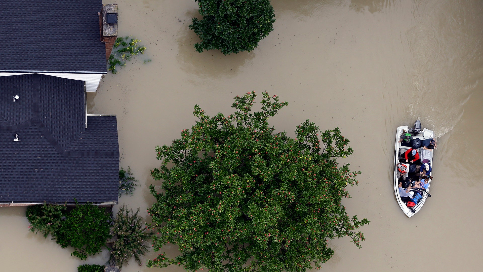Residents evacuate their homes near the Addicks Reservoir as floodwaters from Tropical Storm Harvey rise Tuesday, in Houston