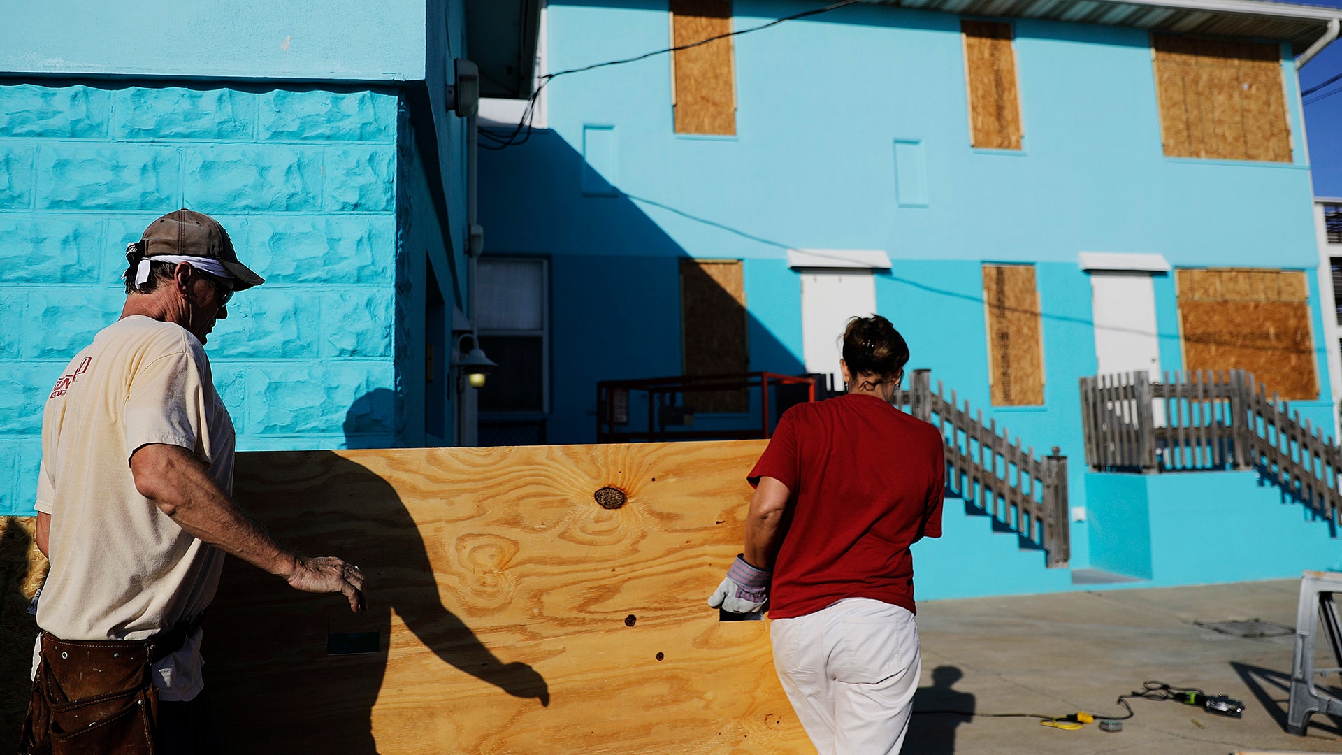 Paulita Kundid, right, and her brother Mike Kundid board up their apartment building ahead of Hurricane Irma in Daytona Beach, Fla., Friday