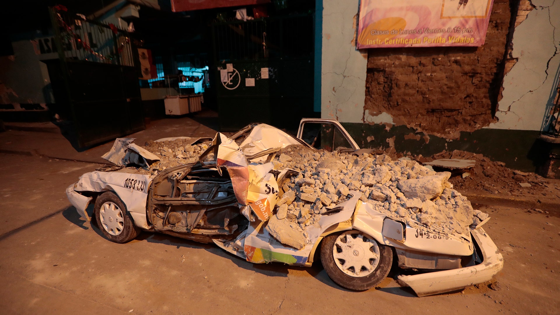 A car stands crushed by rubble after a 7.1 earthquake, in Jojutla, Morelos state, Mexico, Tuesday