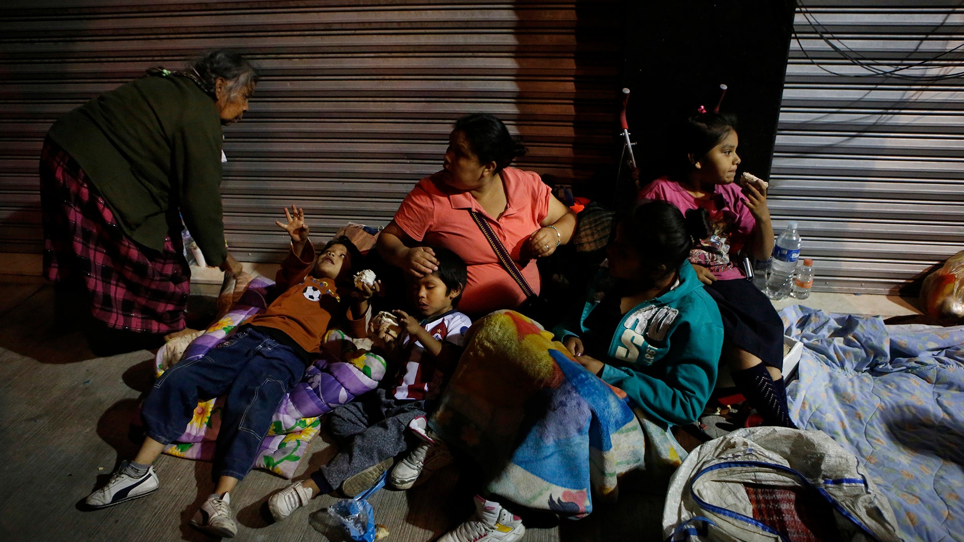 Families fearing aftershocks prepare to sleep on the street in the Roma neighborhood of Mexico City, Tuesday