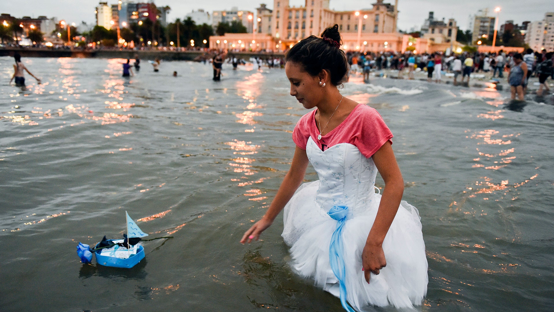 A woman releases a small boat as an offering for the African sea goddess Yemanja, at a beach in Montevideo, Uruguay