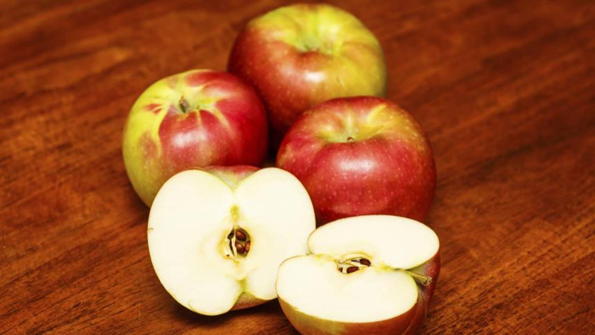 Четверо яблок. Половинка яблока. Яблоко лежит на столе. Разрезанное яблоко лежит. Яблоко разрезанное пополам.
