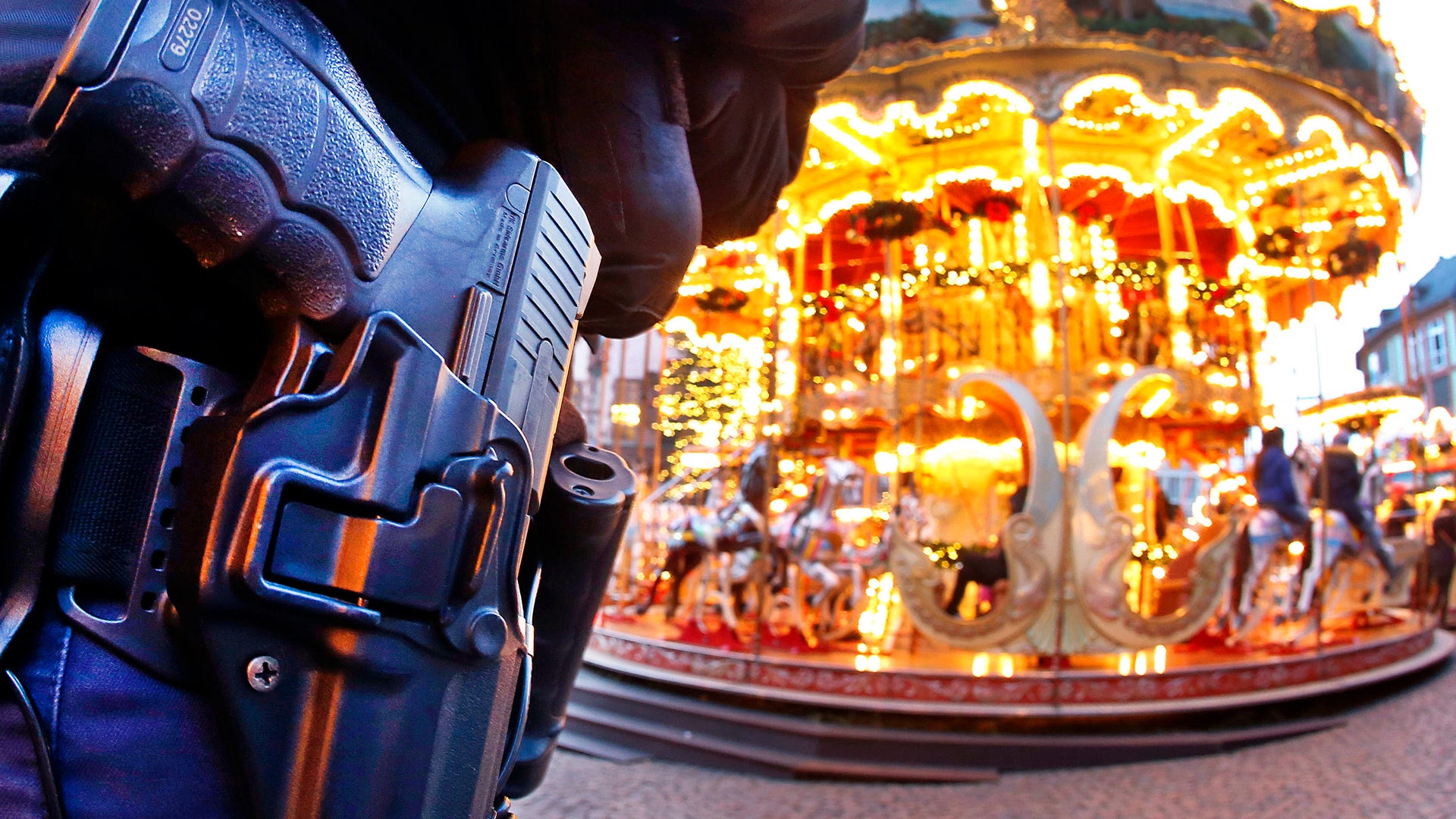 A German police officer stands next to a merry-go-round in the Christmas market in Frankfurt, Germany, Tuesday, Dec. 20, 2016 one day after a truck ran into a crowded Christmas market in Berlin killing several people.