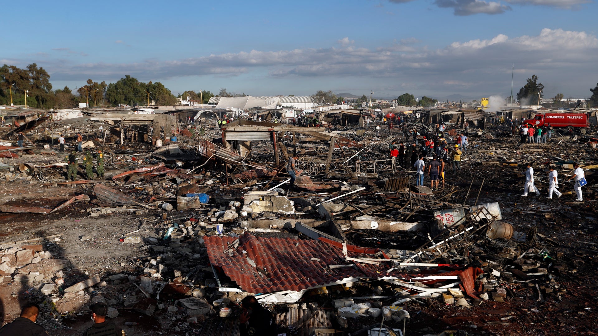 Firefighters and rescue workers walk through the destroyed San Pablito fireworks market on Tuesday, Dec. 20, 2016. 