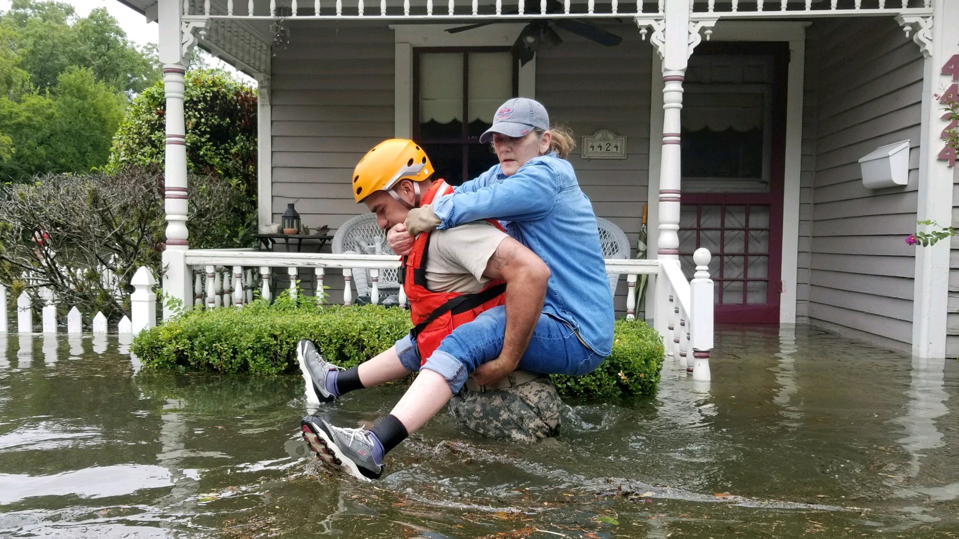 A Texas National Guard soldier carries a woman on his back as they conduct rescue operations in flooded areas around Houston, Sunday