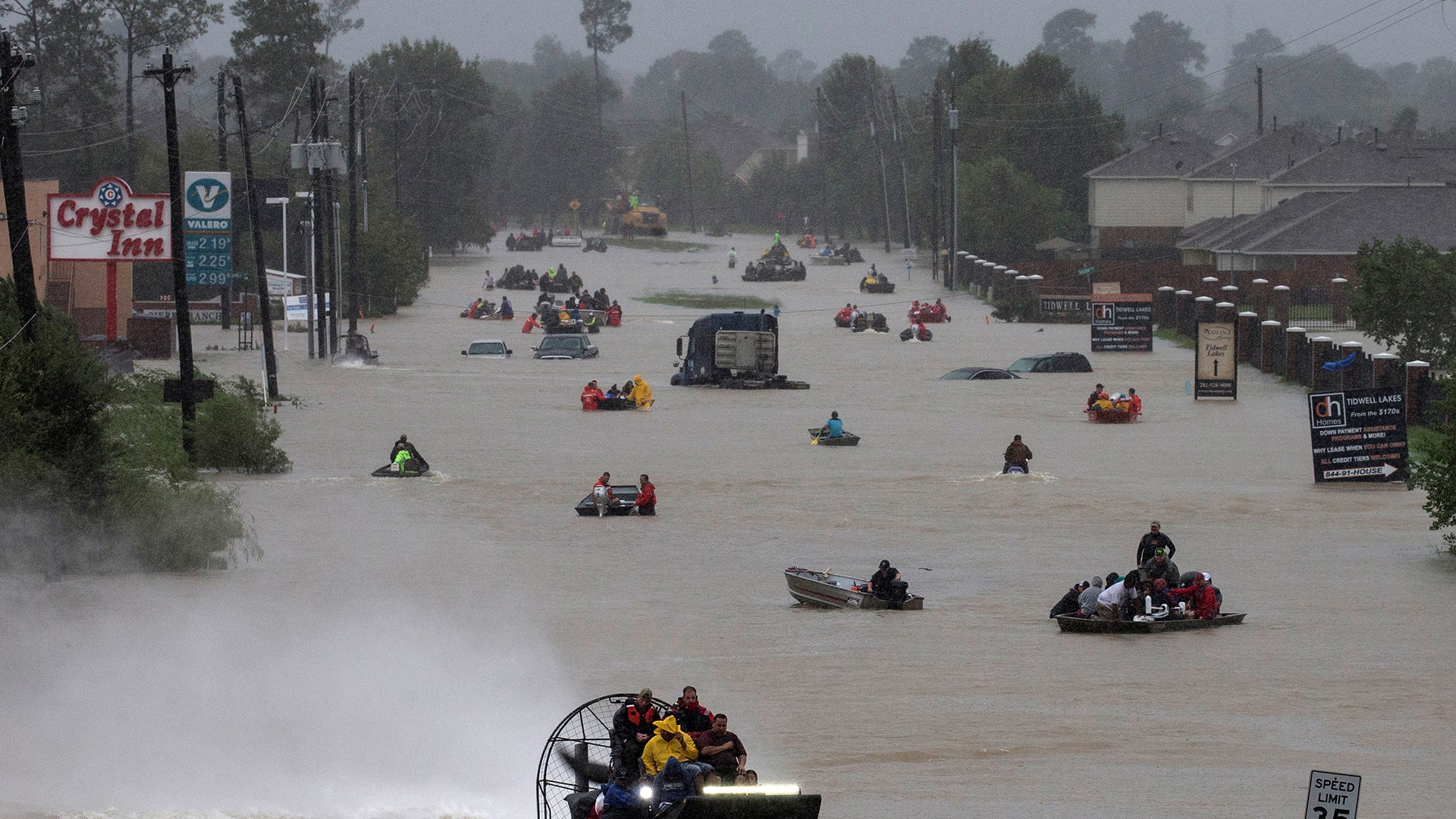 Residents use boats to evacuate flood waters from Tropical Storm Harvey along Tidwell Road east Houston, Monday