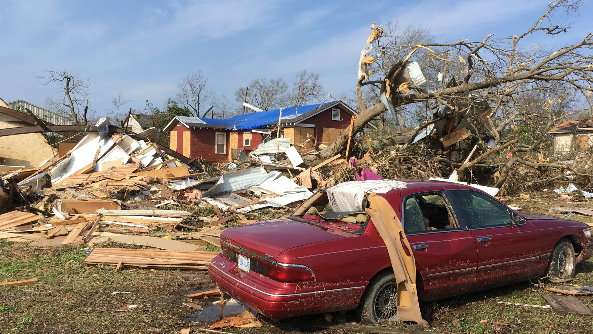A car and house are damaged at the edge of a mobile home park south of downtown Hattiesburg, Miss., Saturday, Jan. 21, 2017.