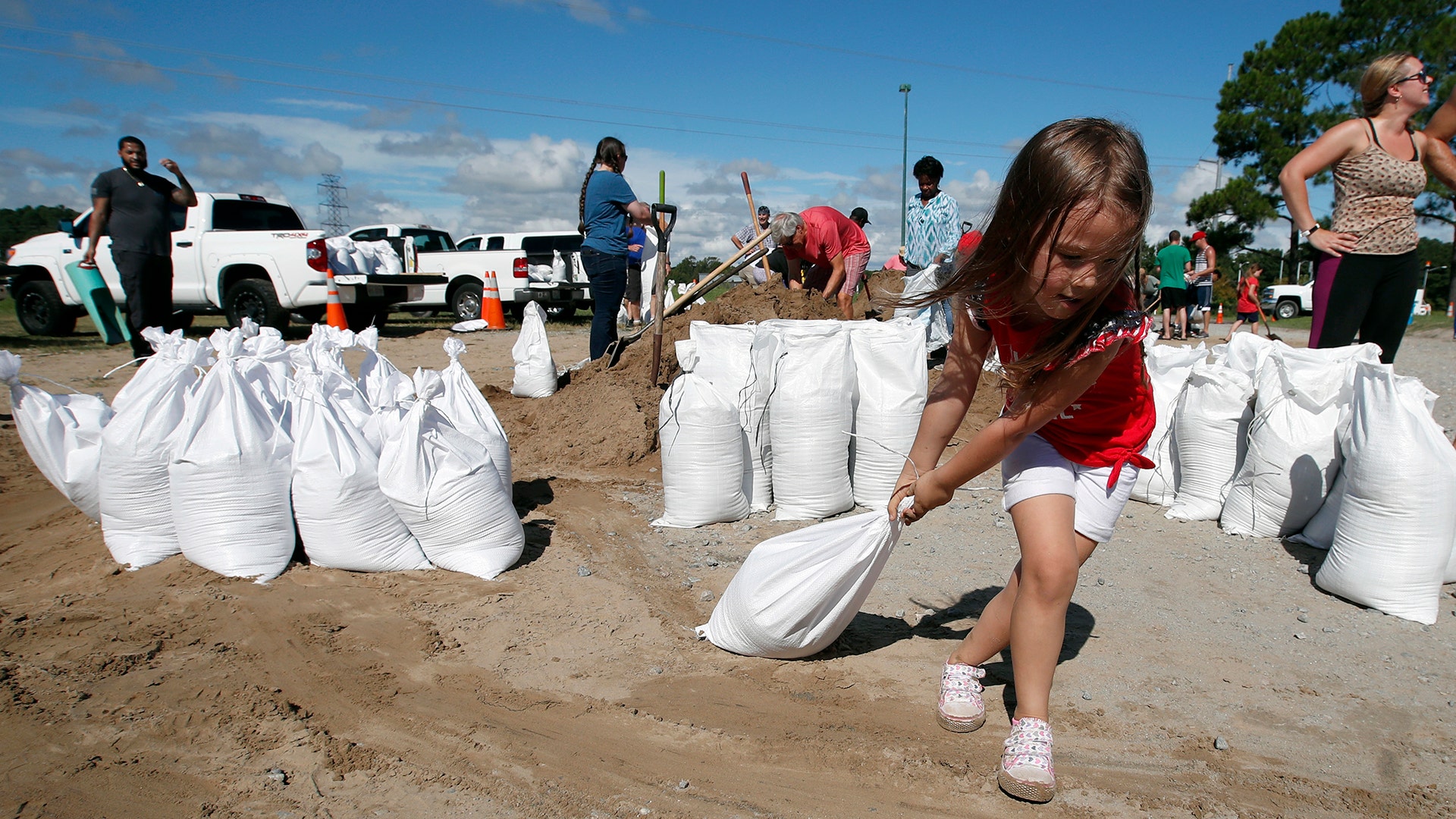 Chloe Heeden drags a sandbag to her father's car in Virginia Beach, Virginia, Wednesday