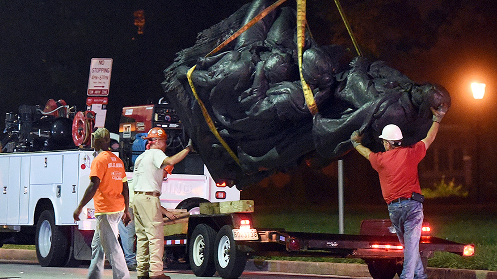 Workers remove a monument dedicated to the Confederate Women of Maryland early Wednesday, Aug 16, 2017