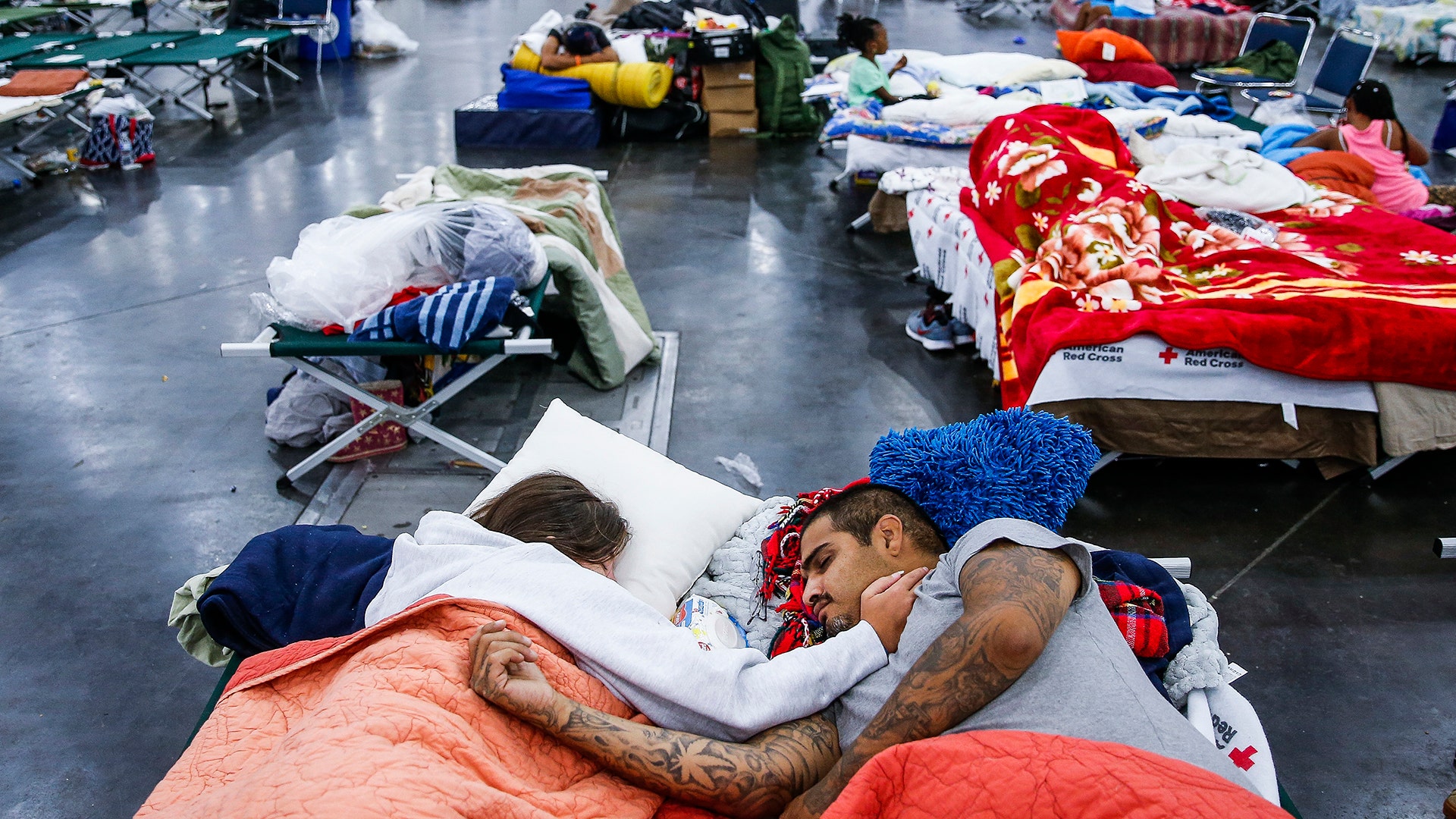 Tammy Dominguez and her husband, Christopher sleep at the George R. Brown Convention Center in Houston, Wednesday